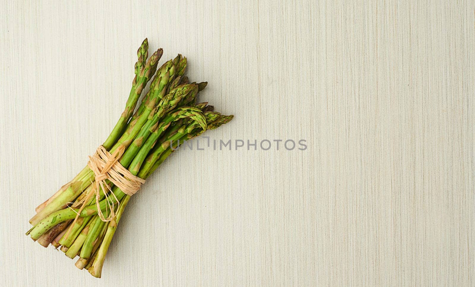 Asparagus, nutrition and vegan ingredients on table top for wellness, health and diet in studio. Vegetables, green and above isolated for eating, food and weight loss in house for prepare and cook. by YuriArcurs