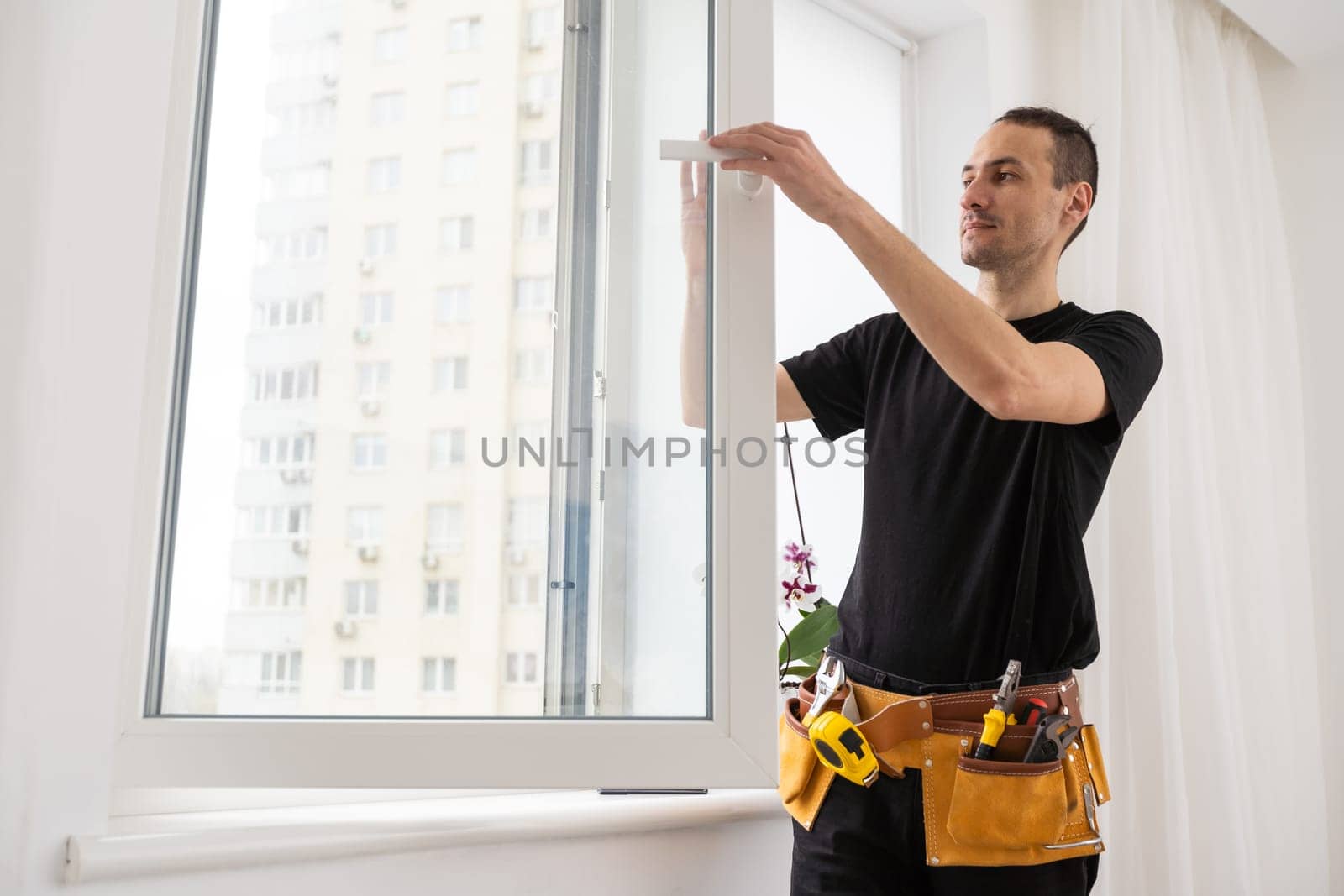 Young worker checking window after repair. High quality photo