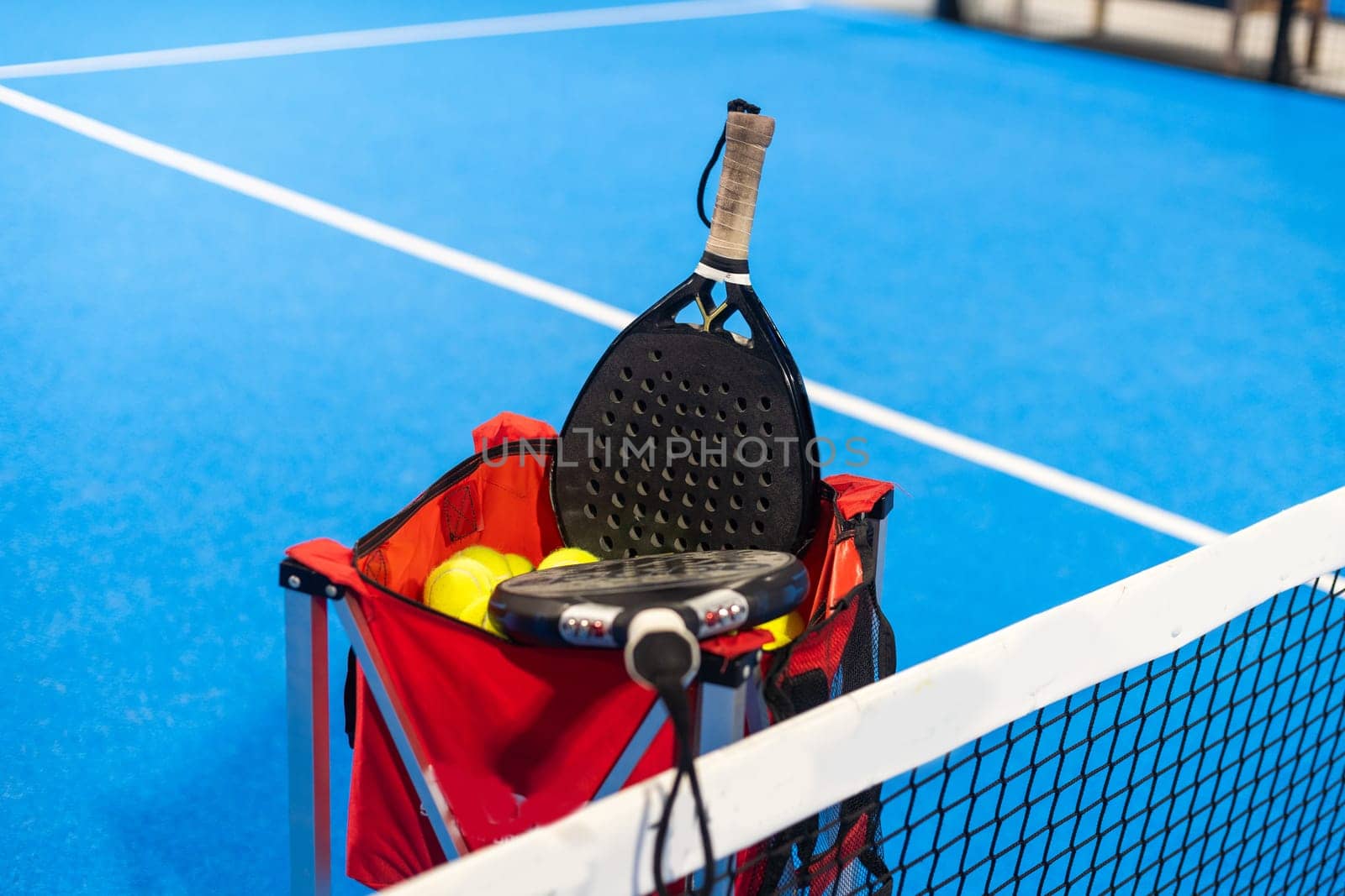 paddle tennis racket and balls on the blue paddle court. High quality photo