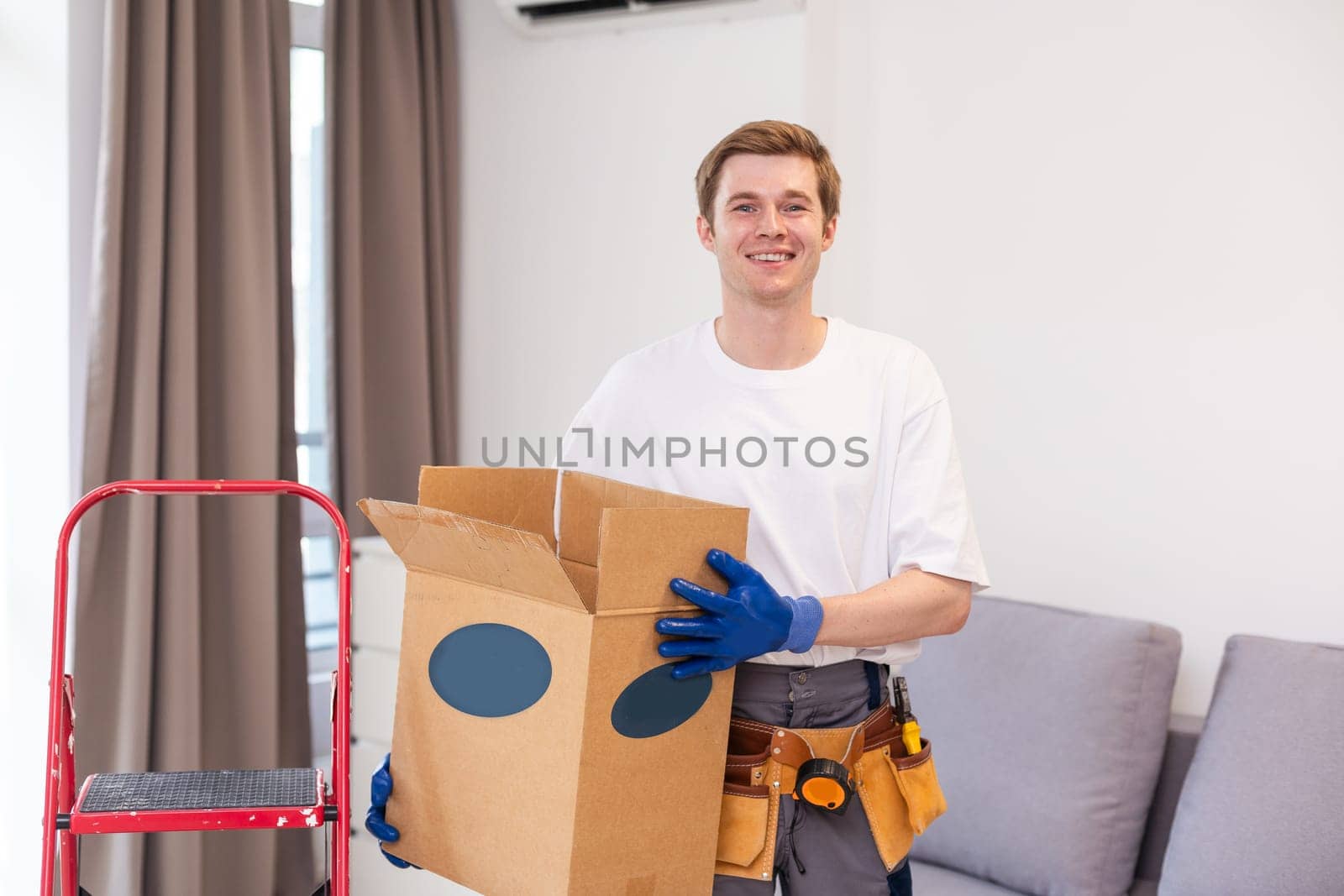 moving, people and real estate concept - happy smiling man holding boxes with stuff at new home.