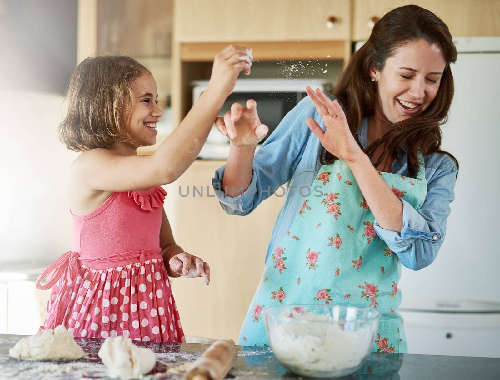 Mother, child and playful baking with dough for homemade cookies at home, bonding or dessert. Woman, daughter and laughing in kitchen while learning for cooking education or pastry, morning or flour by YuriArcurs