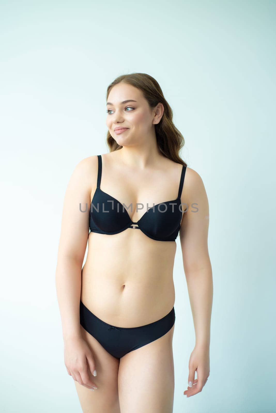 young woman with beautiful hair in black lingerie posing isolated on white background. Model test, snap, polaroid by OleksandrLipko