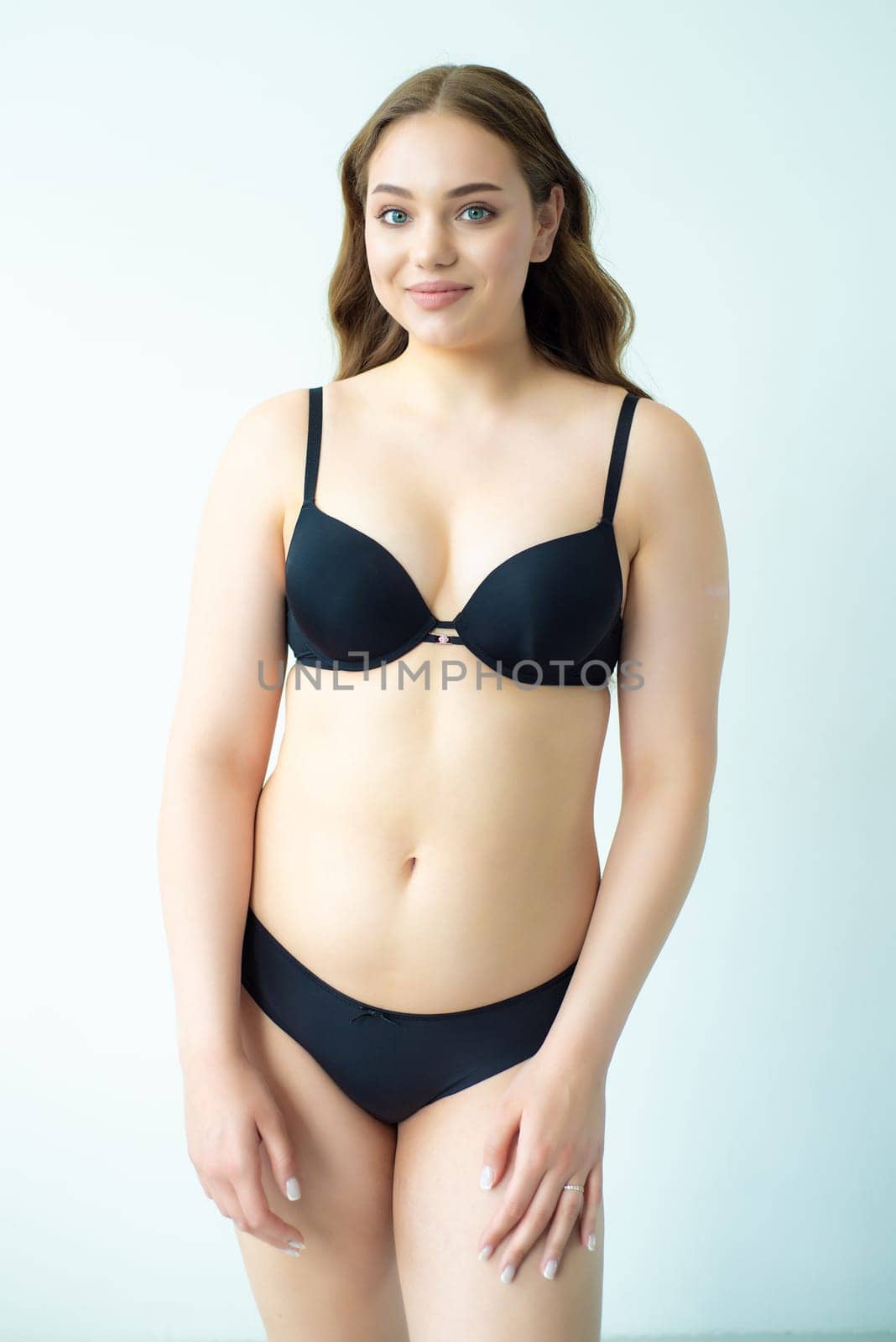 young woman with beautiful hair in black lingerie posing isolated on white background. Model test, snap, polaroid