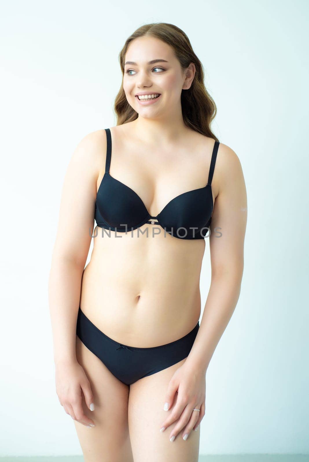 young woman with beautiful hair in black lingerie posing isolated on white background. Model test, snap, polaroid by OleksandrLipko