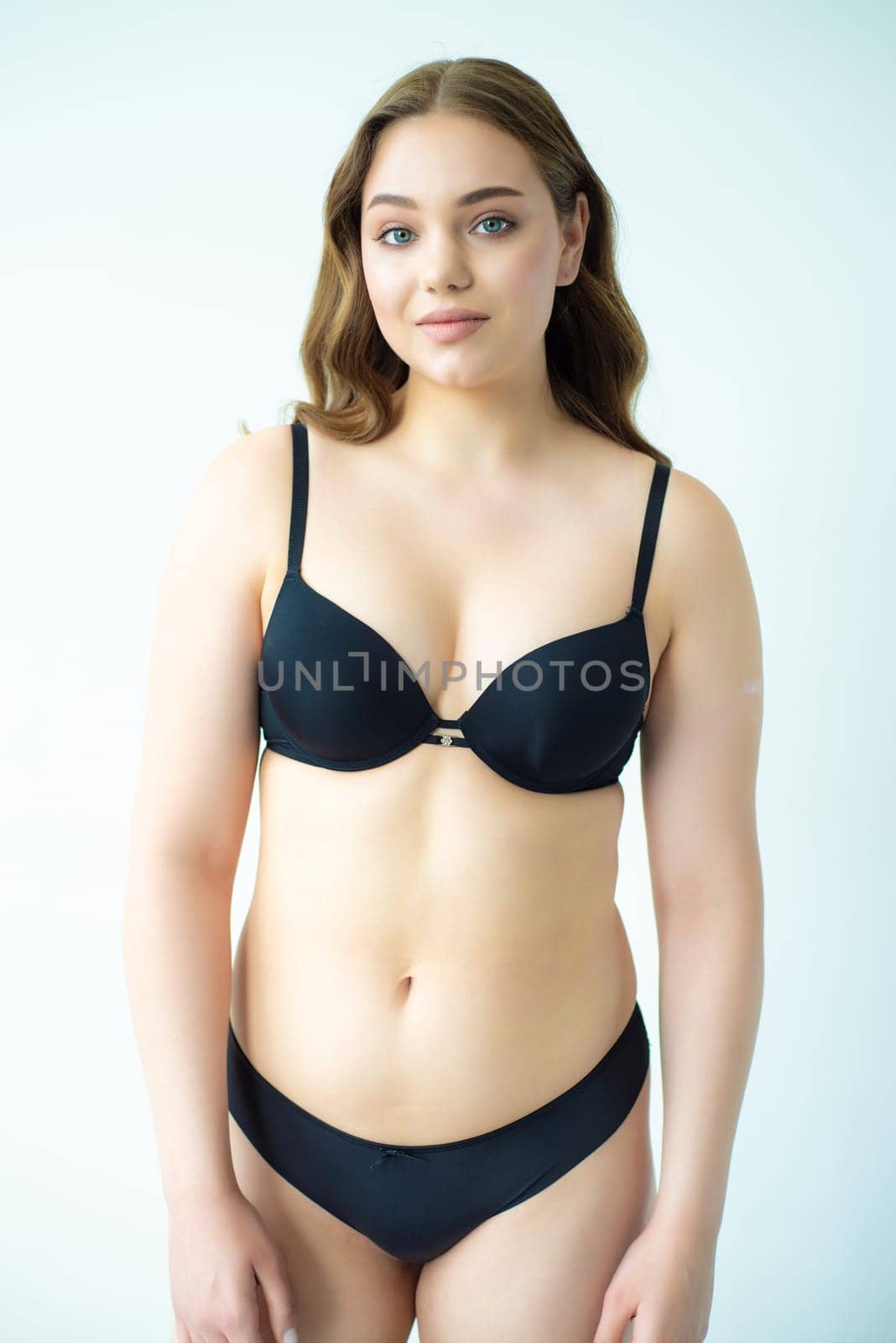 young woman with beautiful hair in black lingerie posing isolated on white background. Model test, snap, polaroid