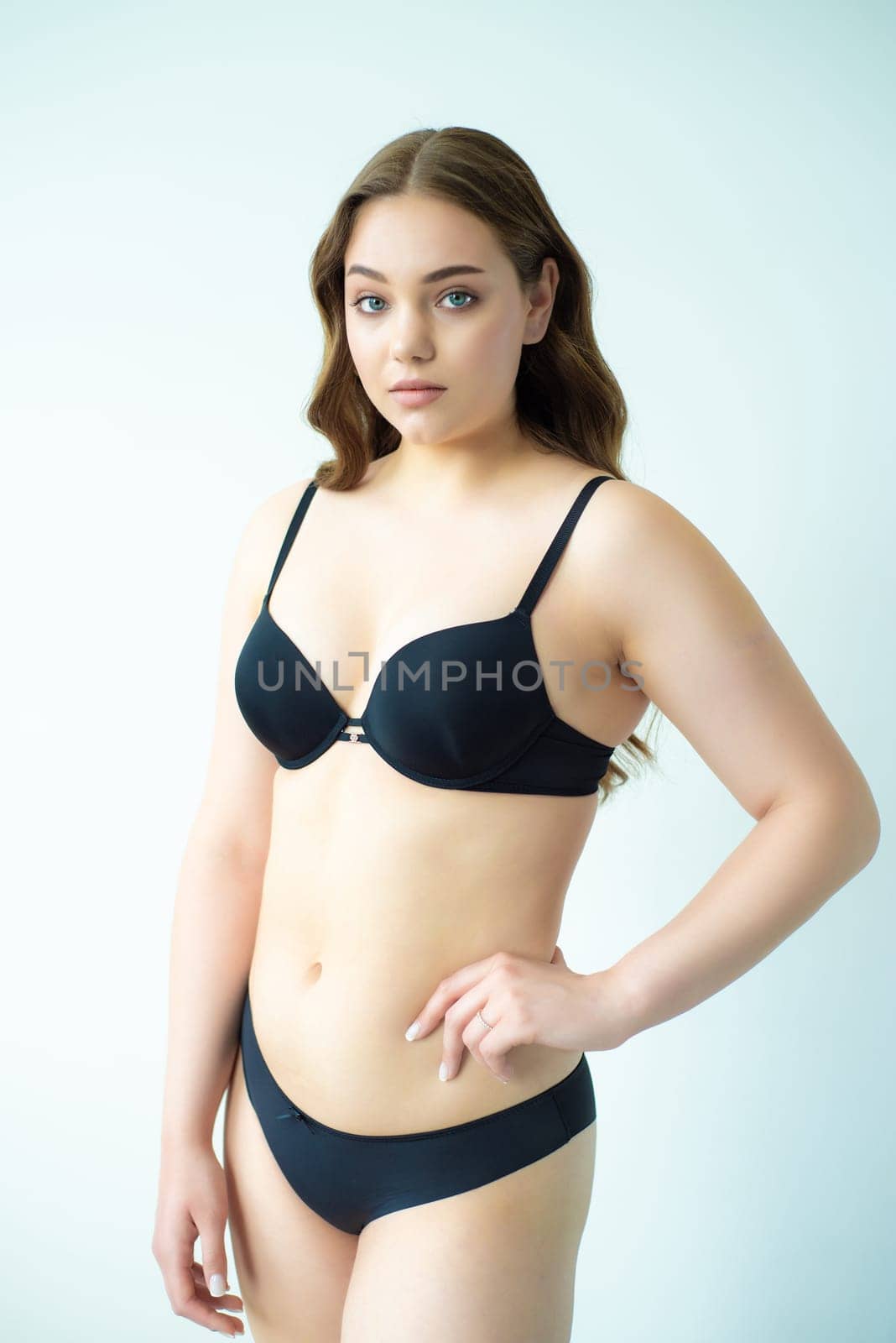 young woman with beautiful hair in black lingerie posing isolated on white background. Model test, snap, polaroid