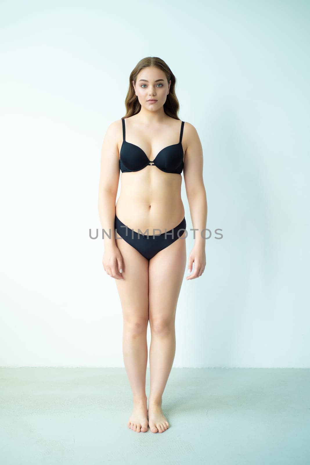 young woman with beautiful hair in black lingerie posing isolated on white background. Model test, snap, polaroid