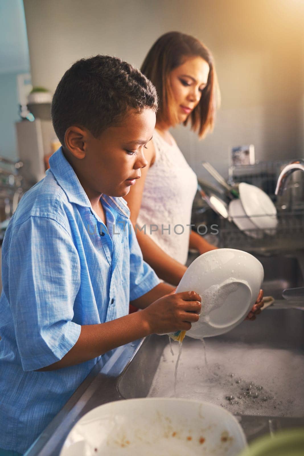 Mother, son and dishes in kitchen with help or teamwork, tasks with collaboration in home. Woman, boy and cleaning plate in house with water and soap, working together or cooperation with happiness by YuriArcurs