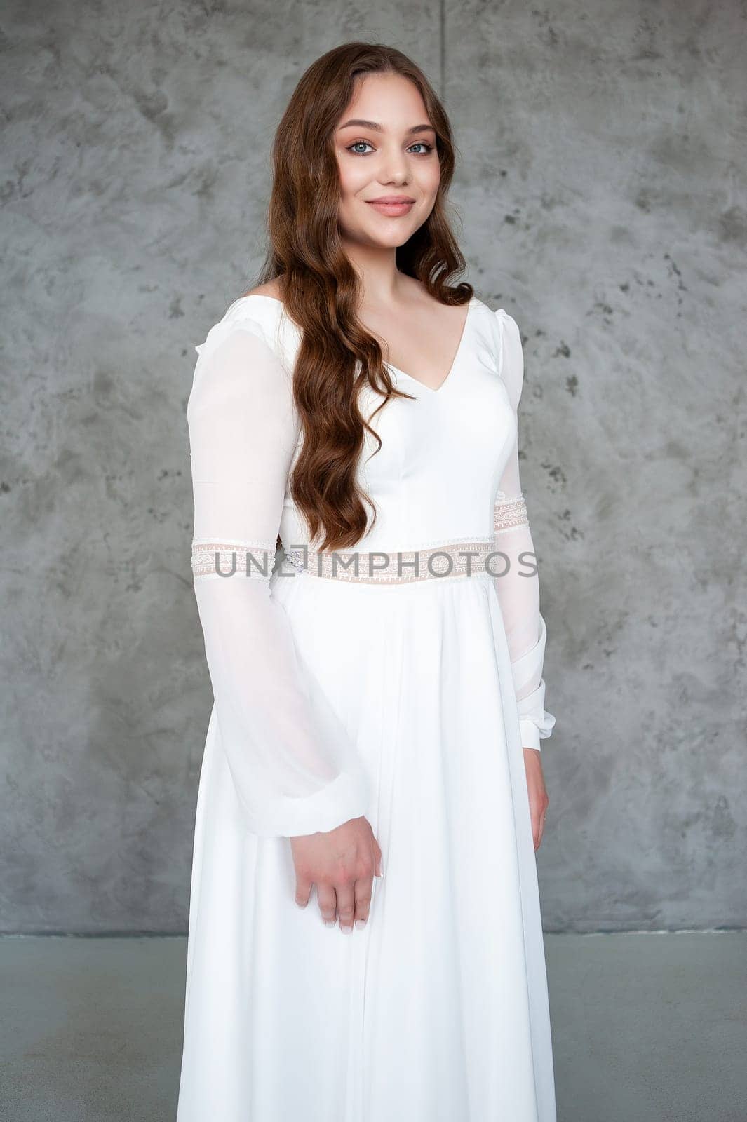 portrait of beautiful young woman in white wedding dress posing in studio