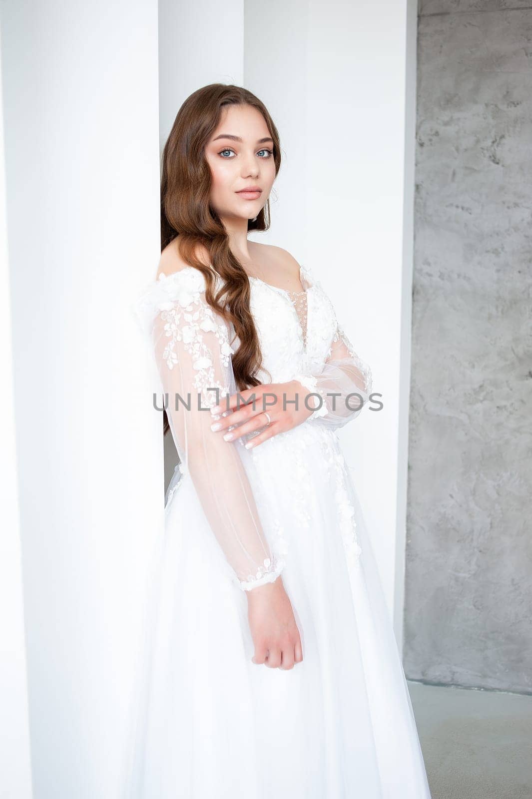 portrait of beautiful young woman in white wedding dress posing in studio