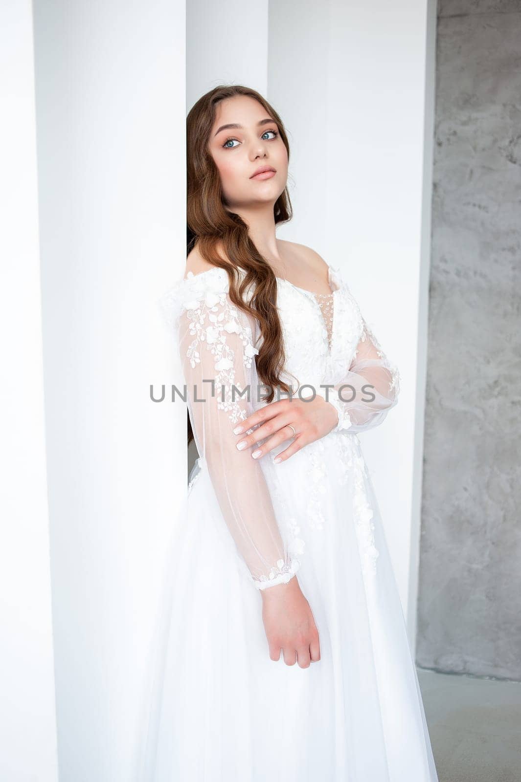 portrait of beautiful young woman in white wedding dress posing in studio