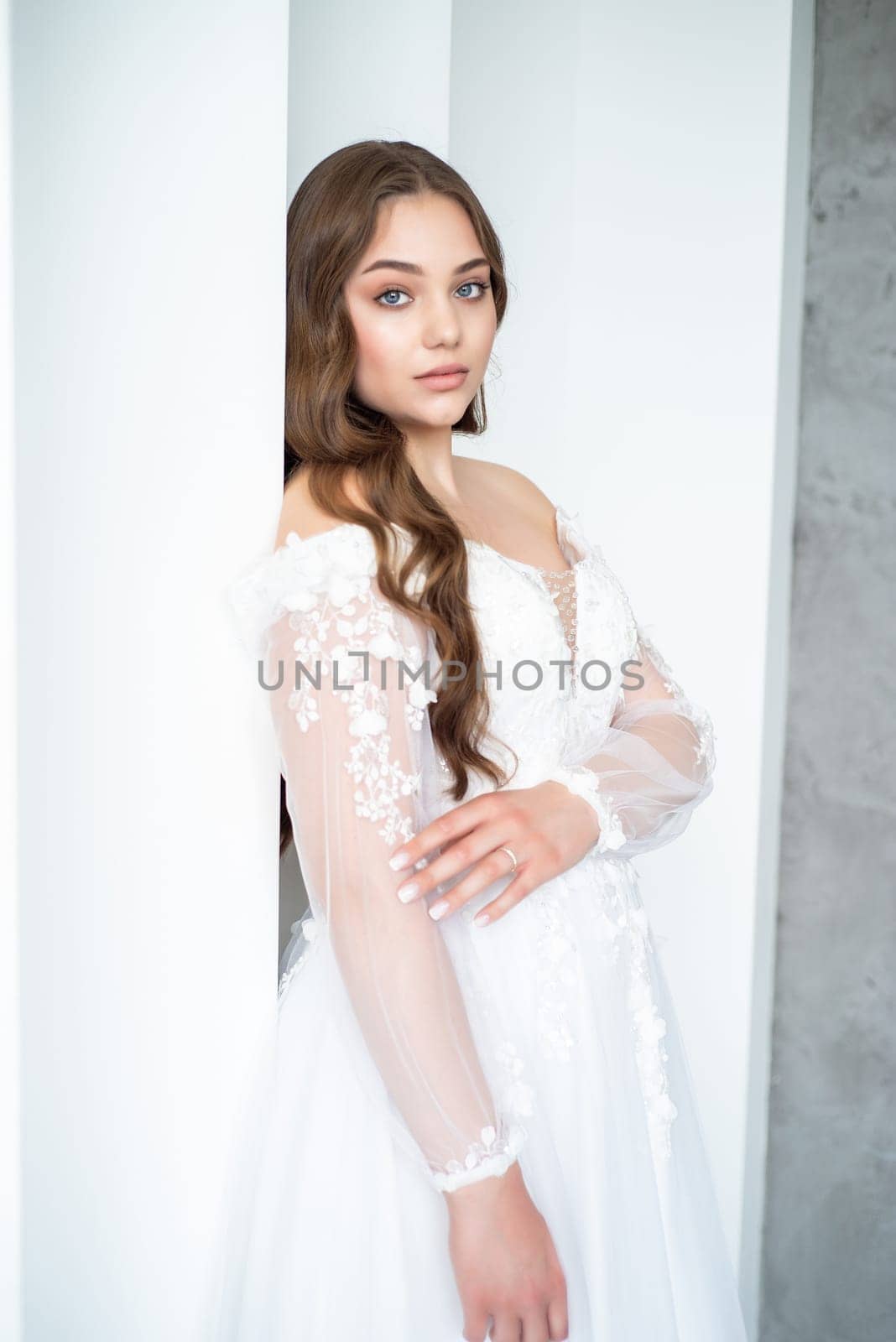 portrait of beautiful young woman in white wedding dress posing in studio