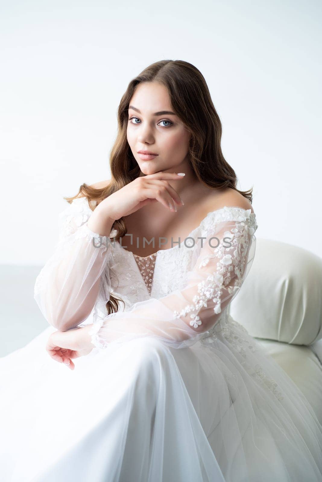 portrait of beautiful young woman in white wedding dress posing in studio