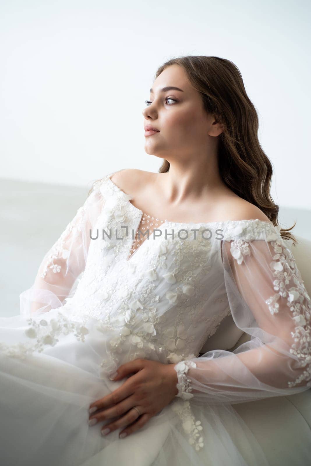 portrait of beautiful young woman in white wedding dress posing in studio