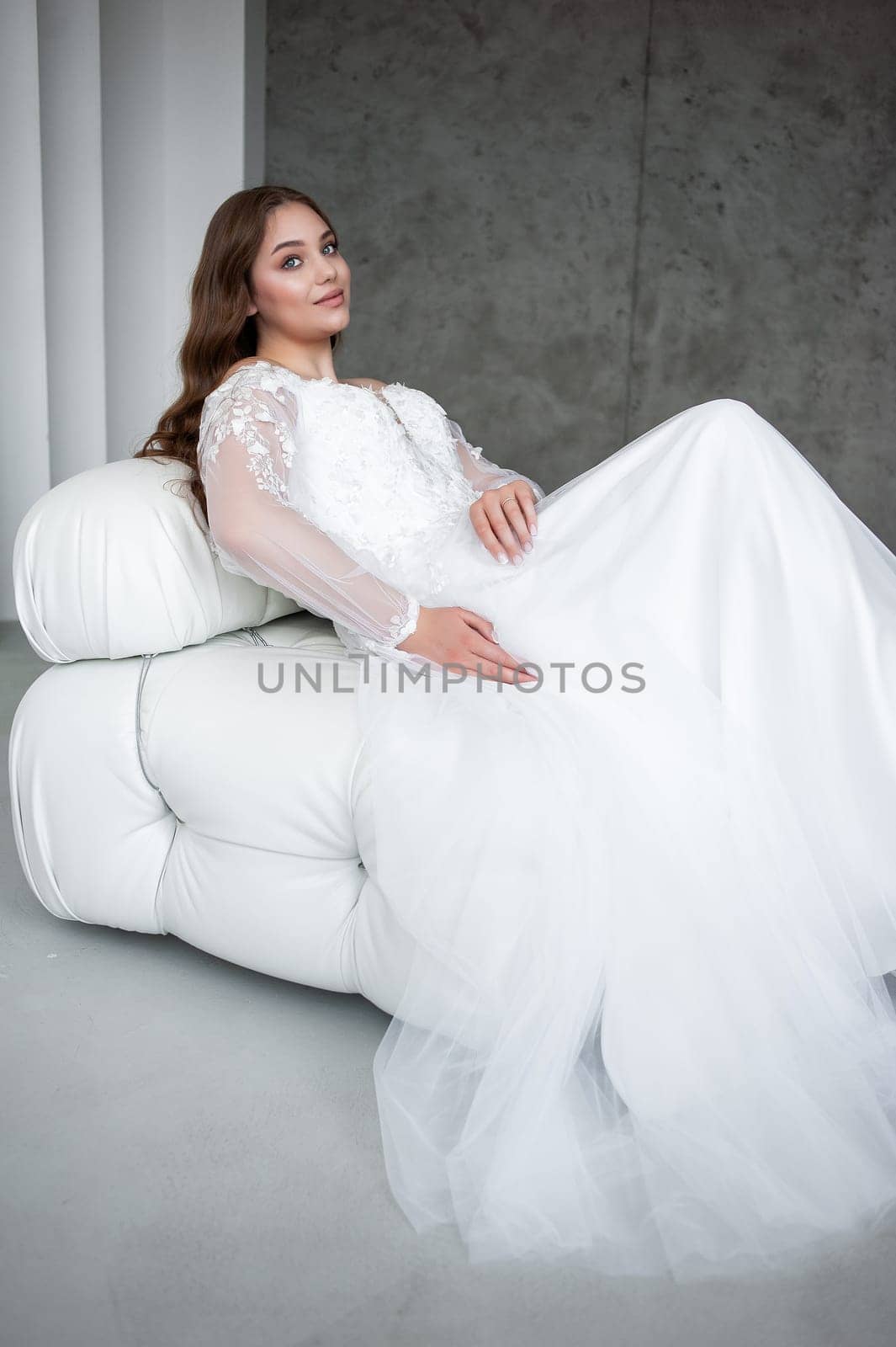 portrait of beautiful young woman in white wedding dress posing in studio