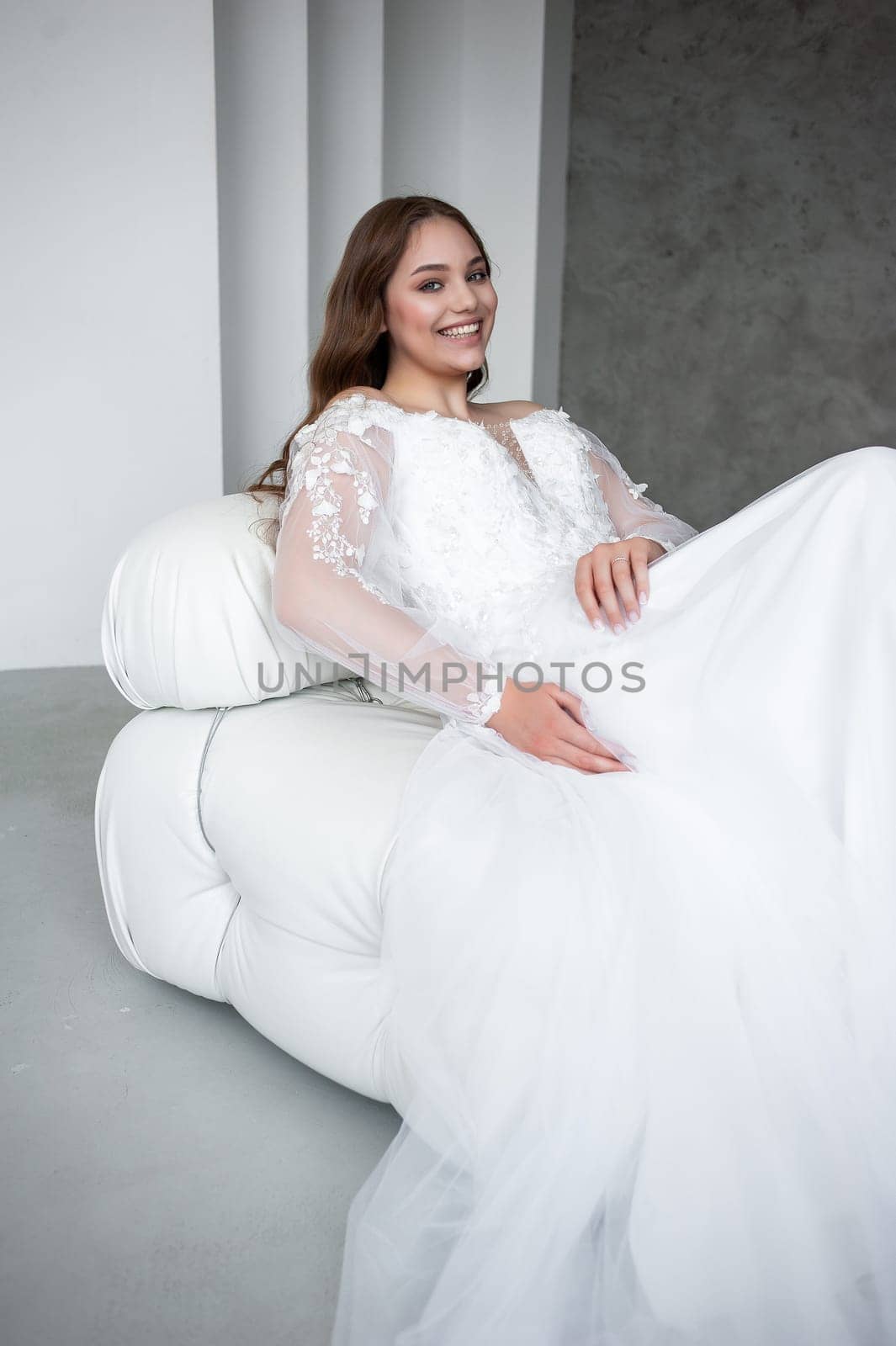 portrait of beautiful young woman in white wedding dress posing in studio