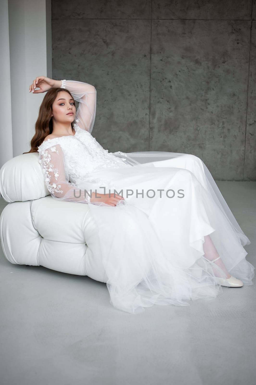 portrait of beautiful young woman in white wedding dress posing in studio