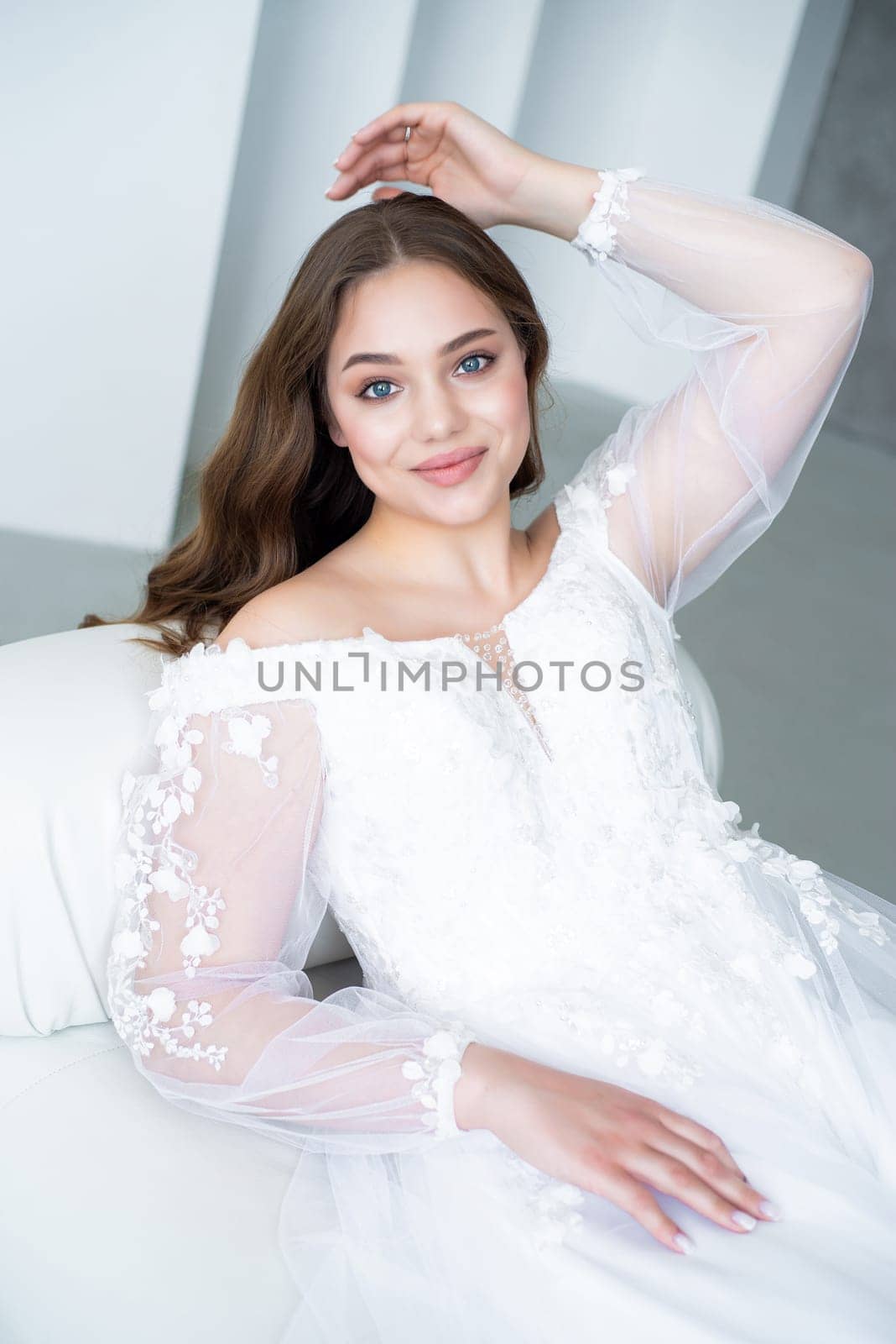 portrait of beautiful young woman in white wedding dress posing in studio