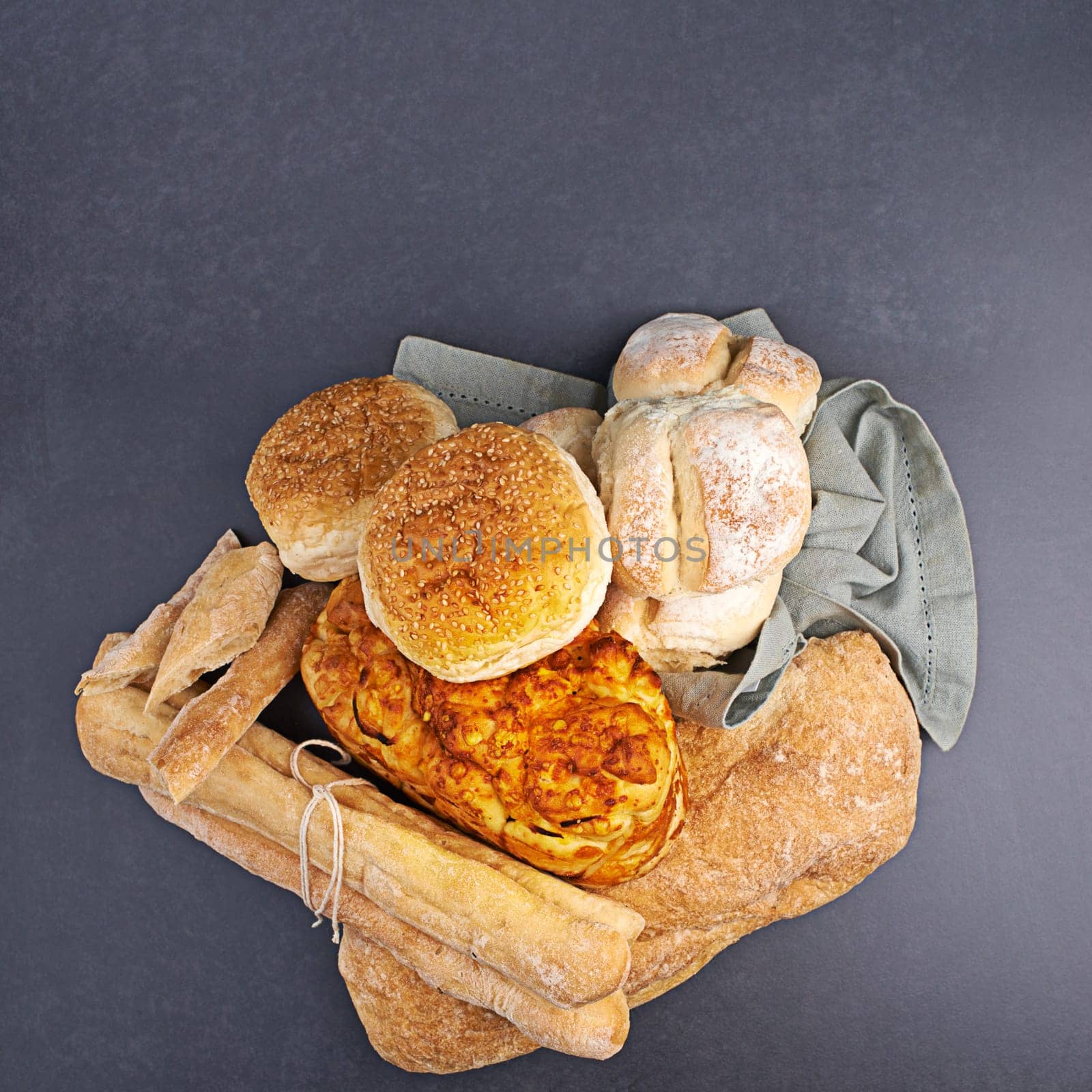 Group, bread and roll by dark background for bakery, sandwich and Italian food on surface with carbs. Bun, baguette and gluten free with wheat on countertop for healthy eating, hamburger and focaccia.