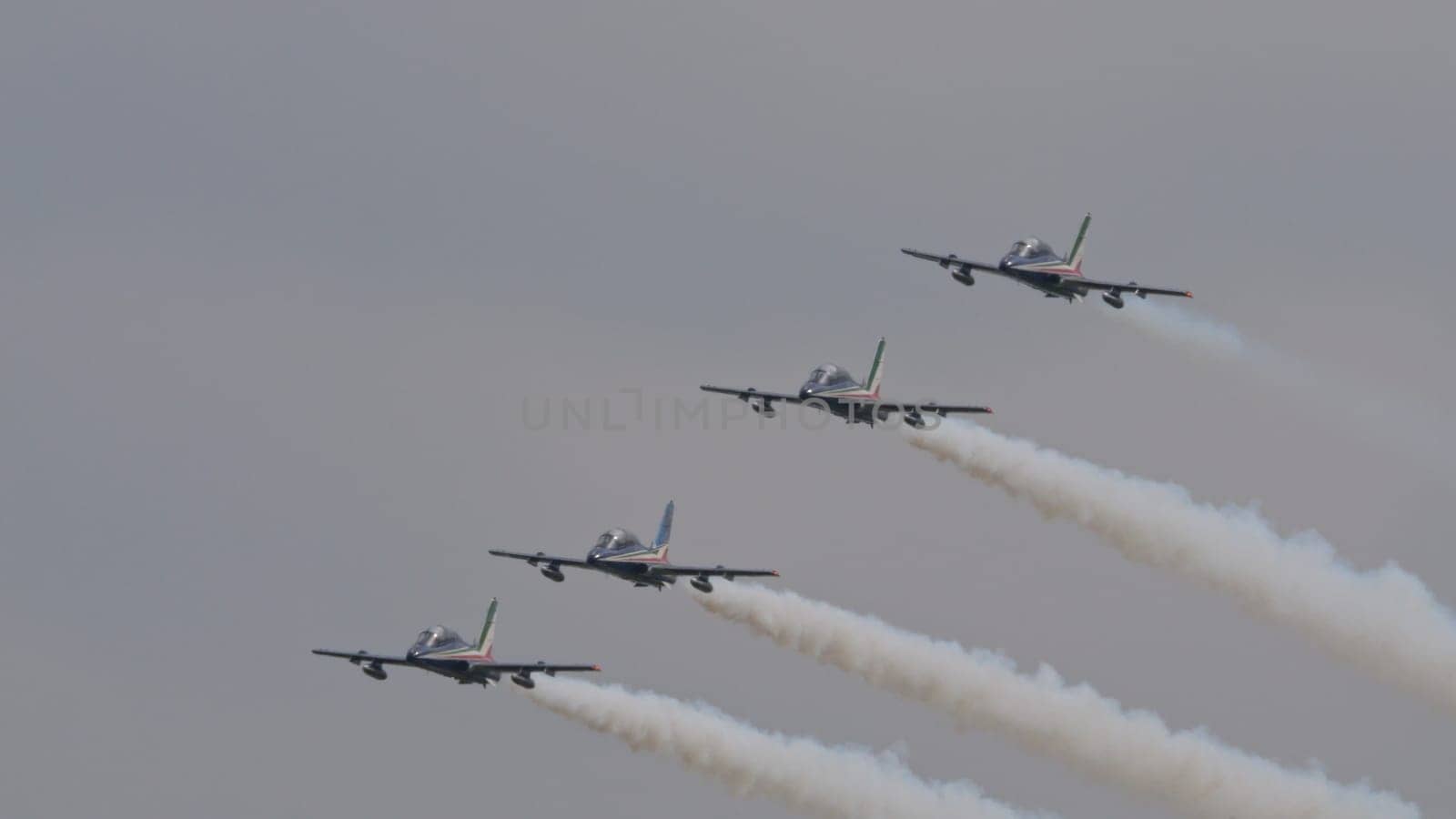 Istrana Italy April 5 2024: Formation of Four Military Aircrafts in Flight with White Smoke. Aermacchi MB-339 of Frecce Tricolori the Italian Air Force Aerobatic Team. Copy Space
