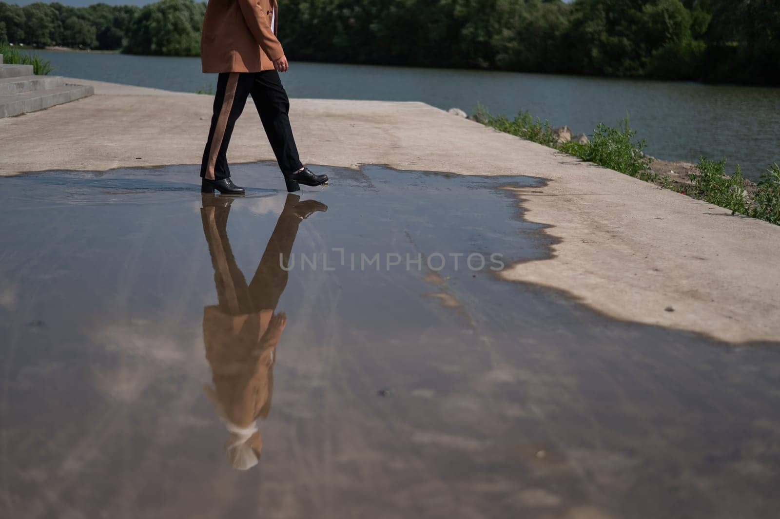Close-up of a woman's legs walking on a large puddle. by mrwed54
