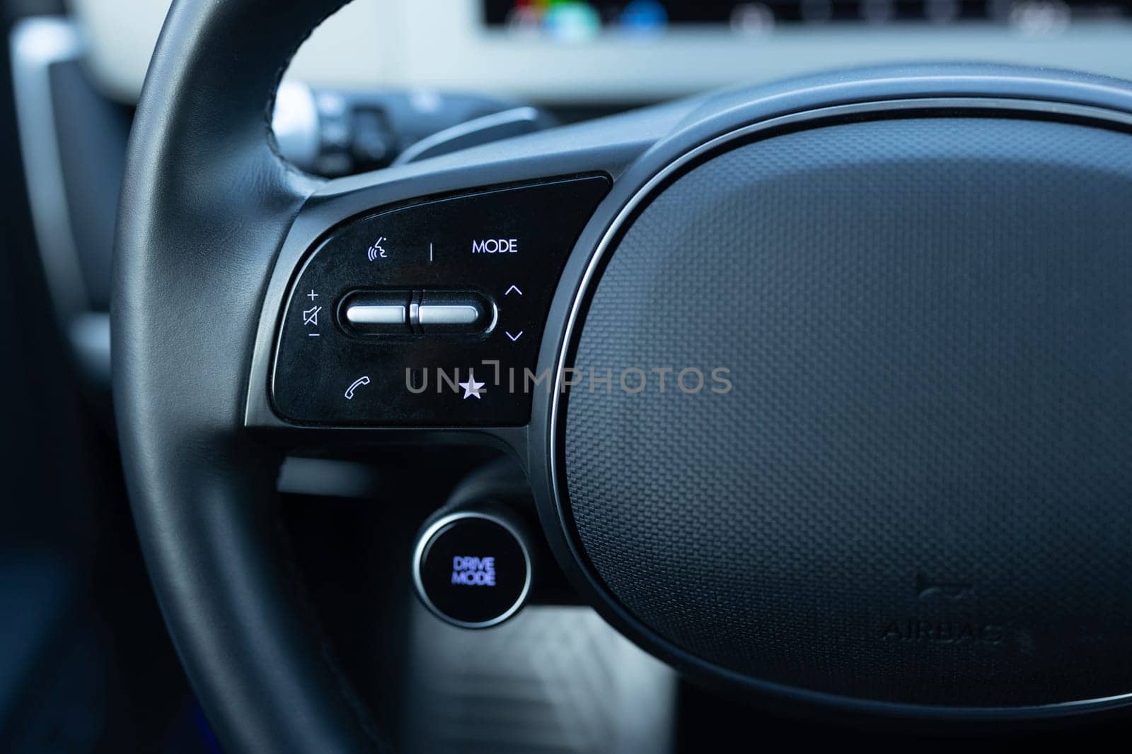 Close-up view of car interior. View of steering wheel of car control music. Volume button of car radio on steering wheel. Turns up the volume of the music in the car. Drive mode by uflypro