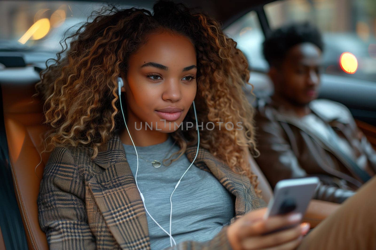 a woman is sitting in the back seat of a car listening to music on her phone by richwolf