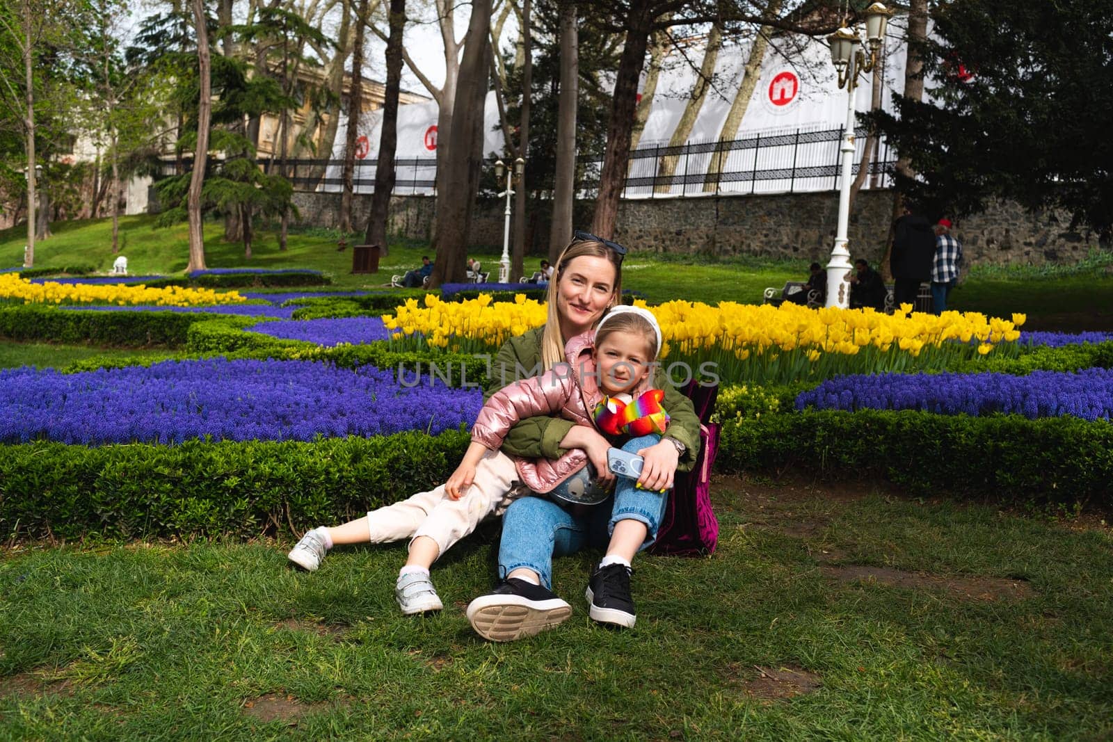 Mother and daughter enjoying a good time outdoors in city park close up