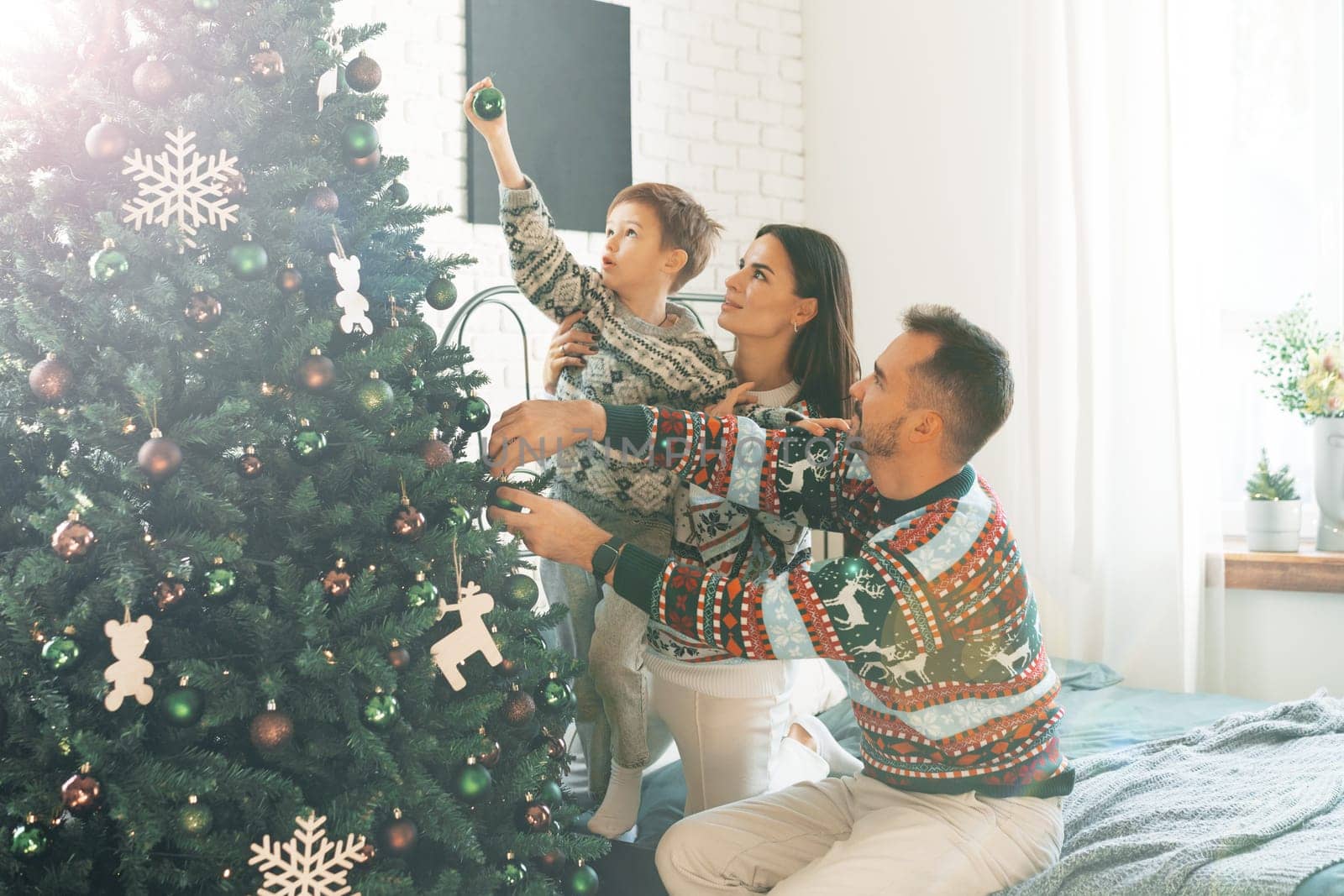 Happy family near fir-tree in bedroom, Christmas celebration at home by Fabrikasimf