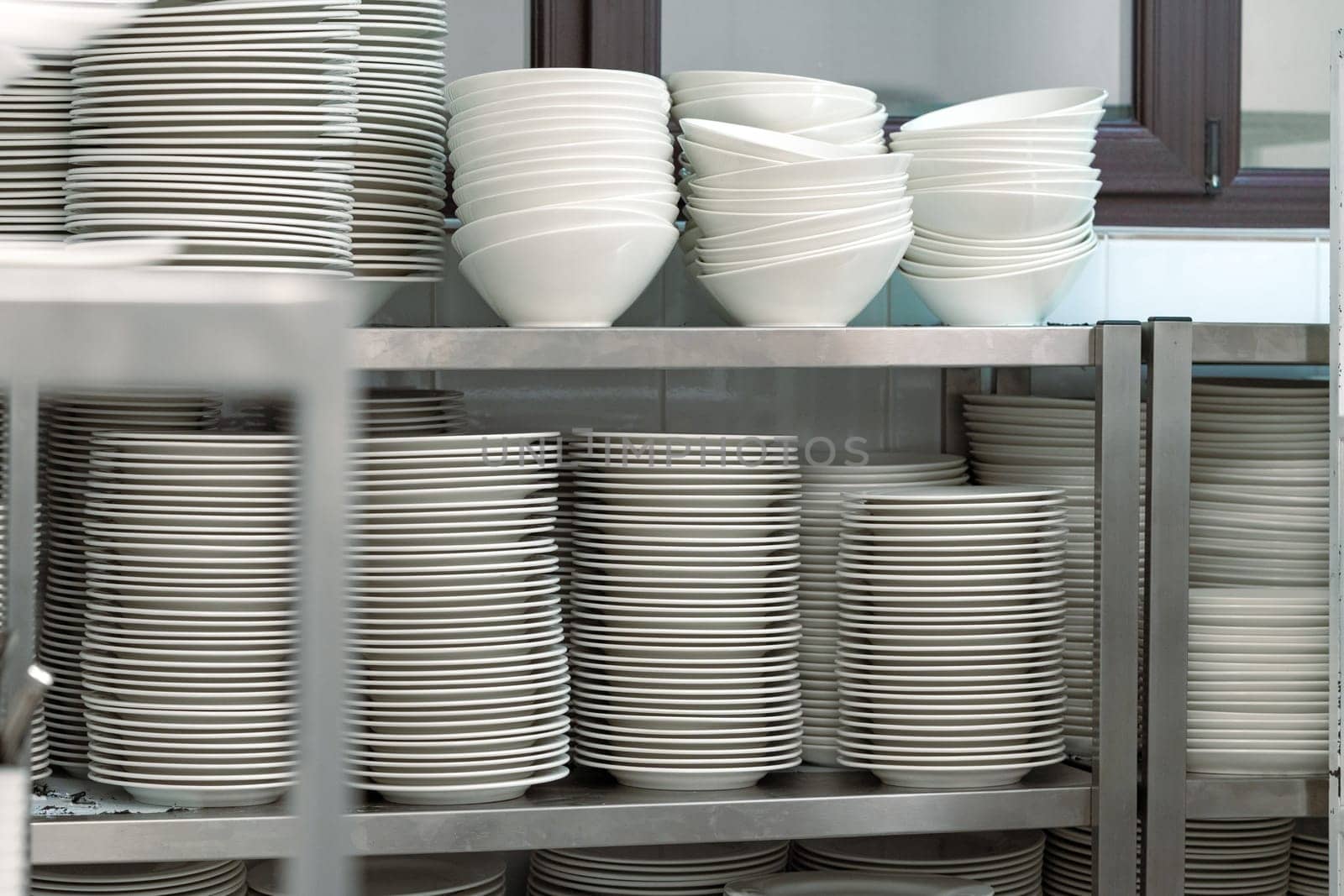 Plenty of stacked plates in the kitchen cupboard close up