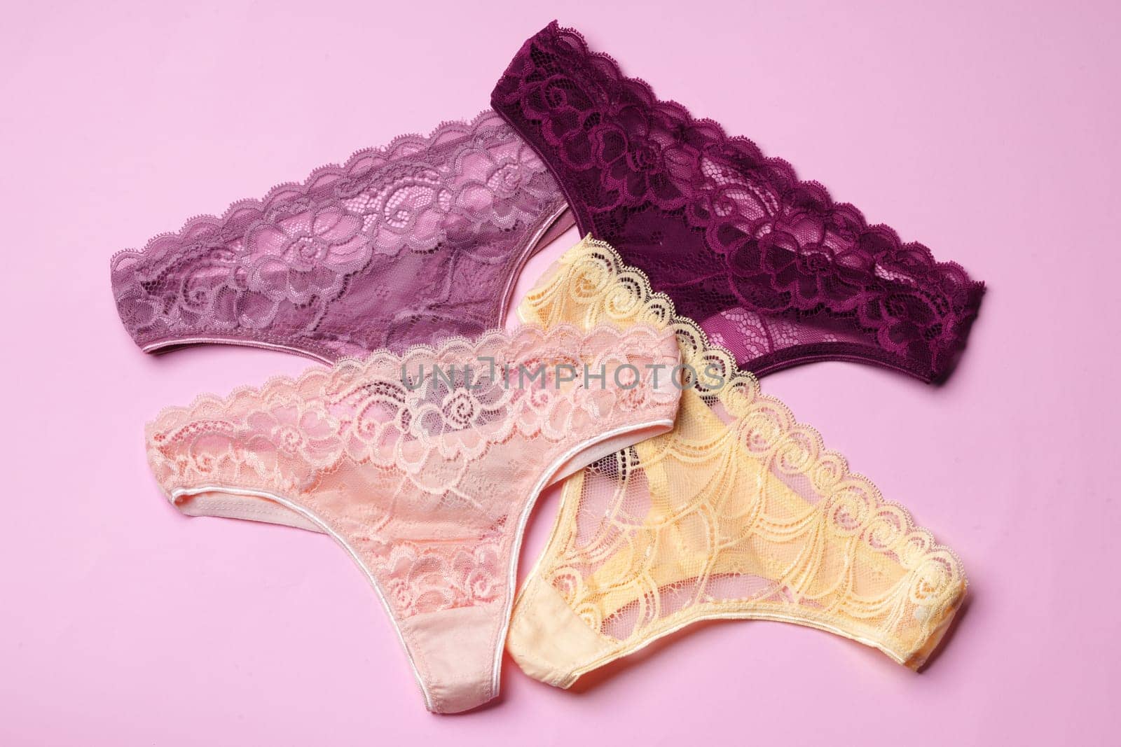 Women's panties on pink background with copy space flat lay