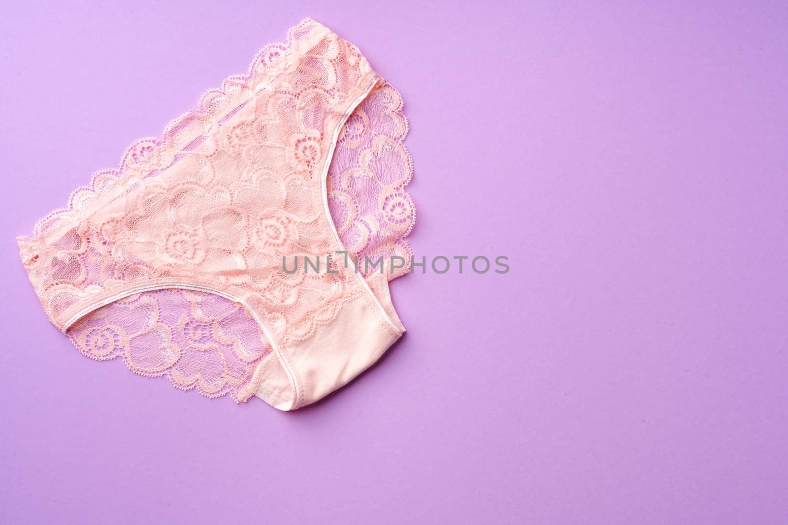 Women's panties on pink background with copy space flat lay