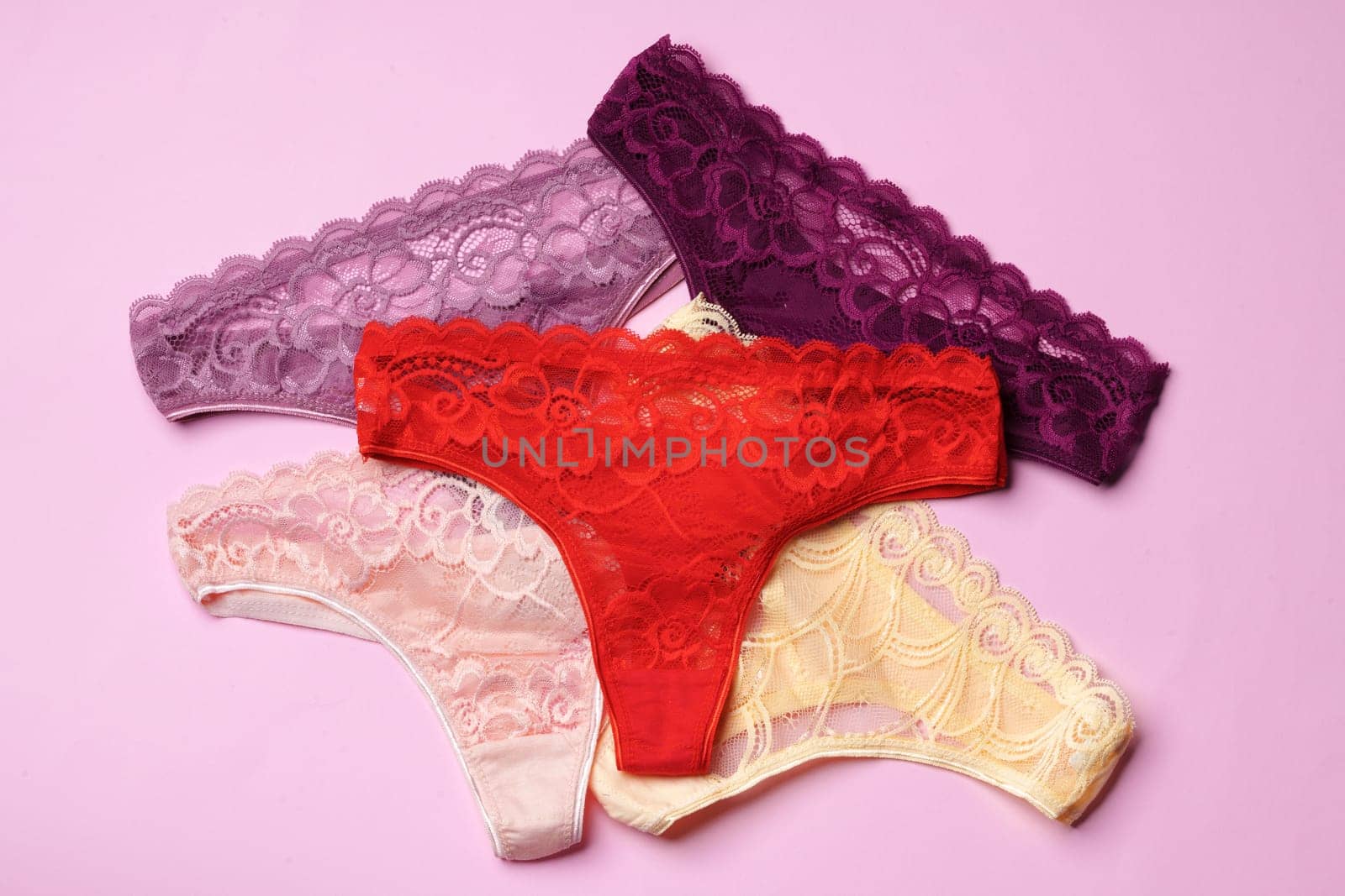 Women's panties on pink background with copy space flat lay