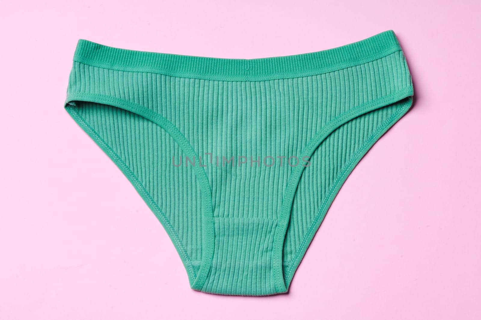Women's panties on pink background with copy space flat lay