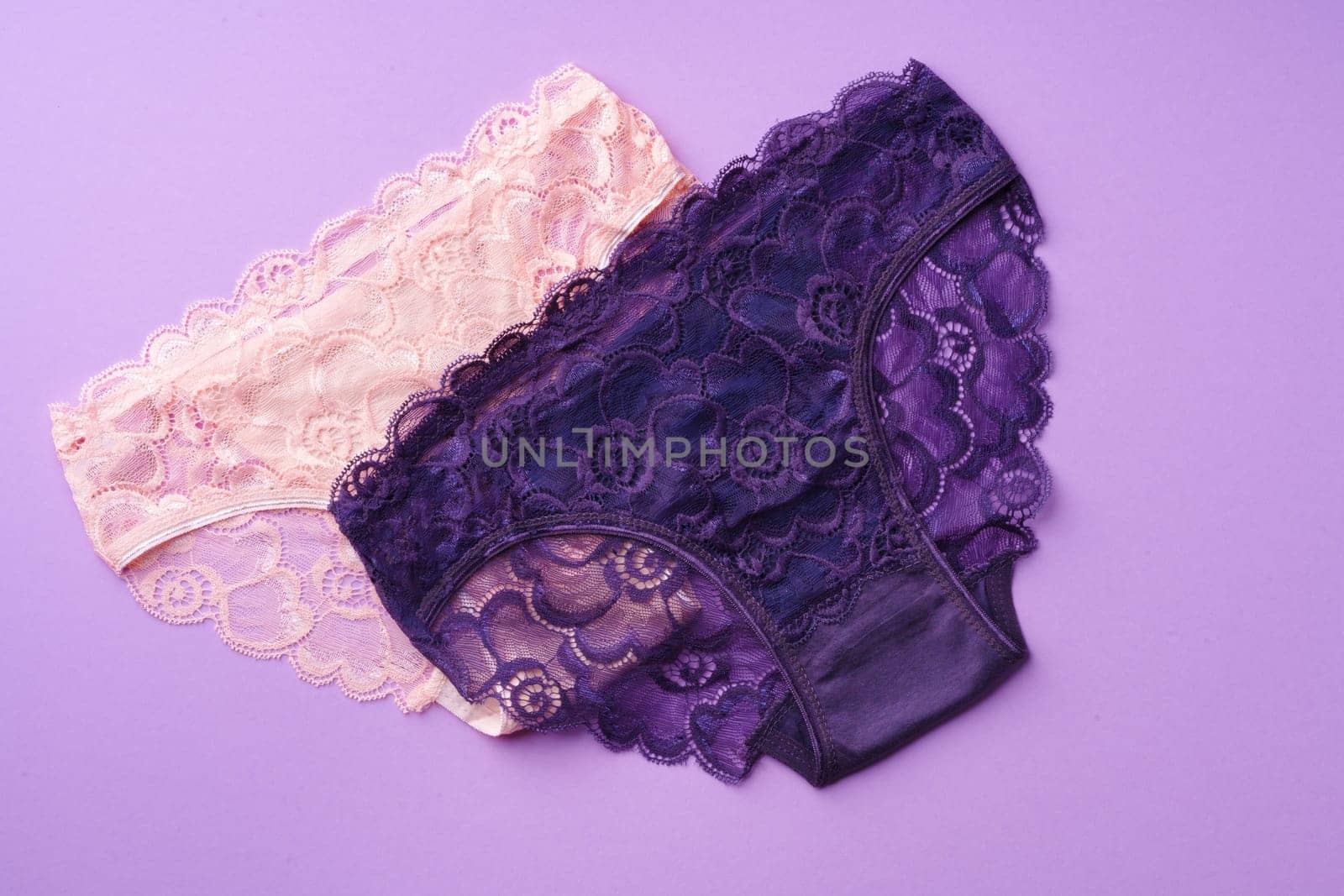 Women's panties on pink background with copy space flat lay