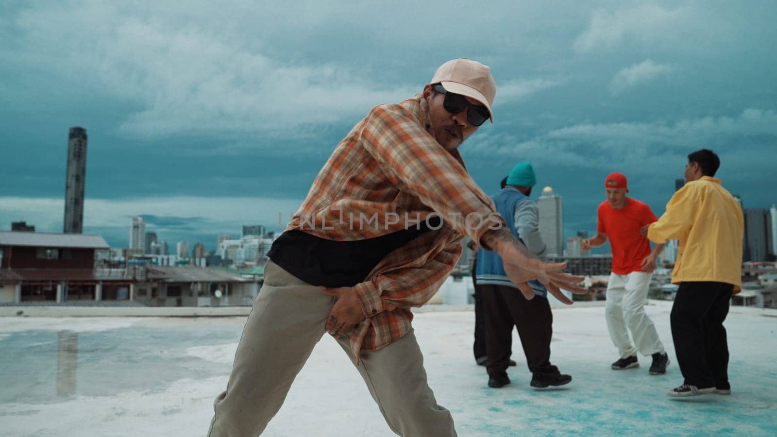 Professional asian street dancer practice B boy dance while multicultural friends at roof top. Young modern dancing group doing hip hop movement. Style,fashion,action. Outdoor sport 2024. Endeavor.