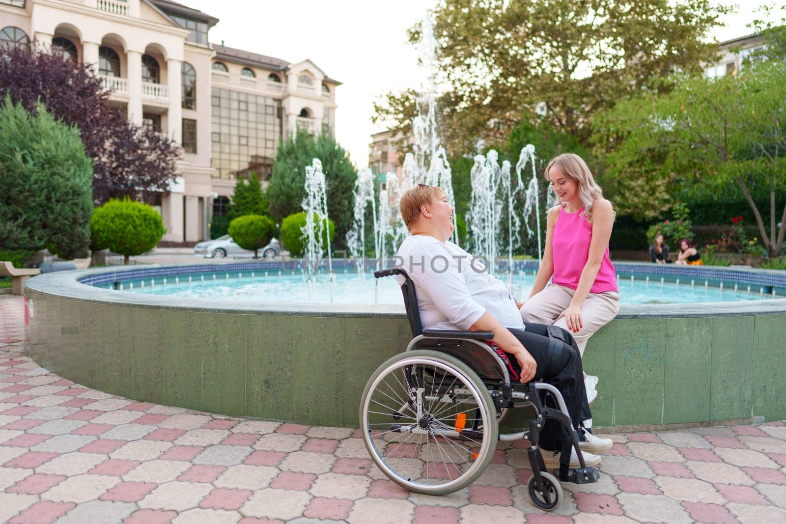 Young daughter taking care of her mother with disability sitting in wheelchair, portrait