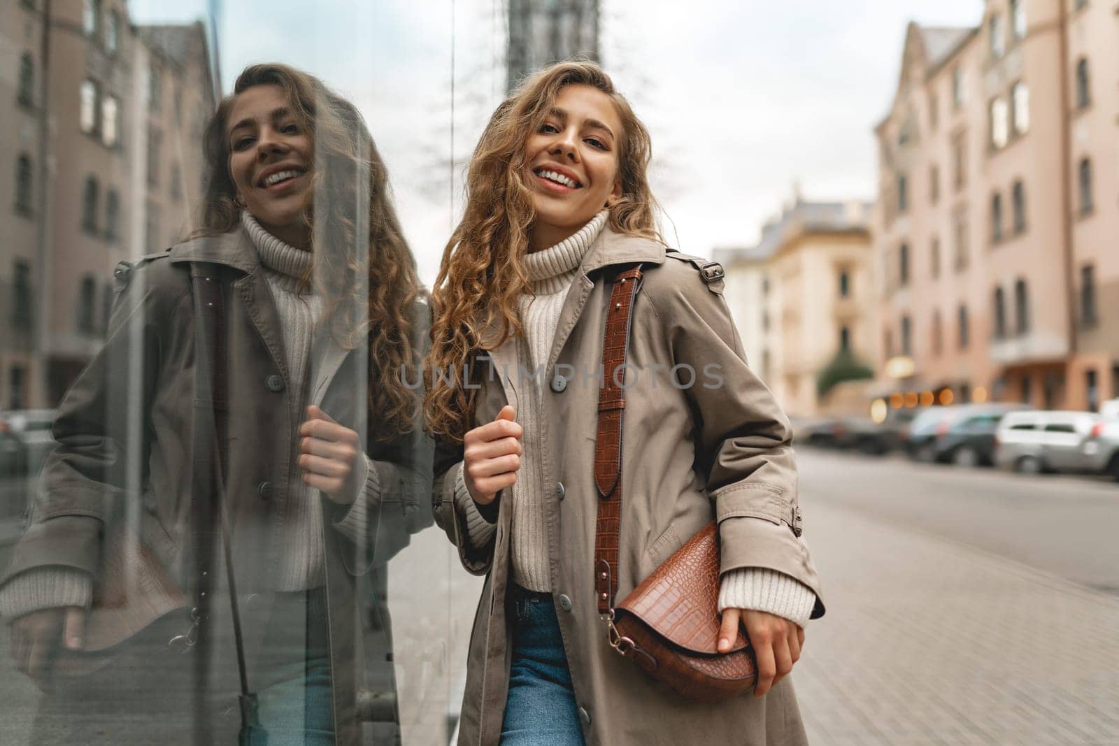 Autumn portrait of young fashionable woman wearing trendy coat in the street, close up