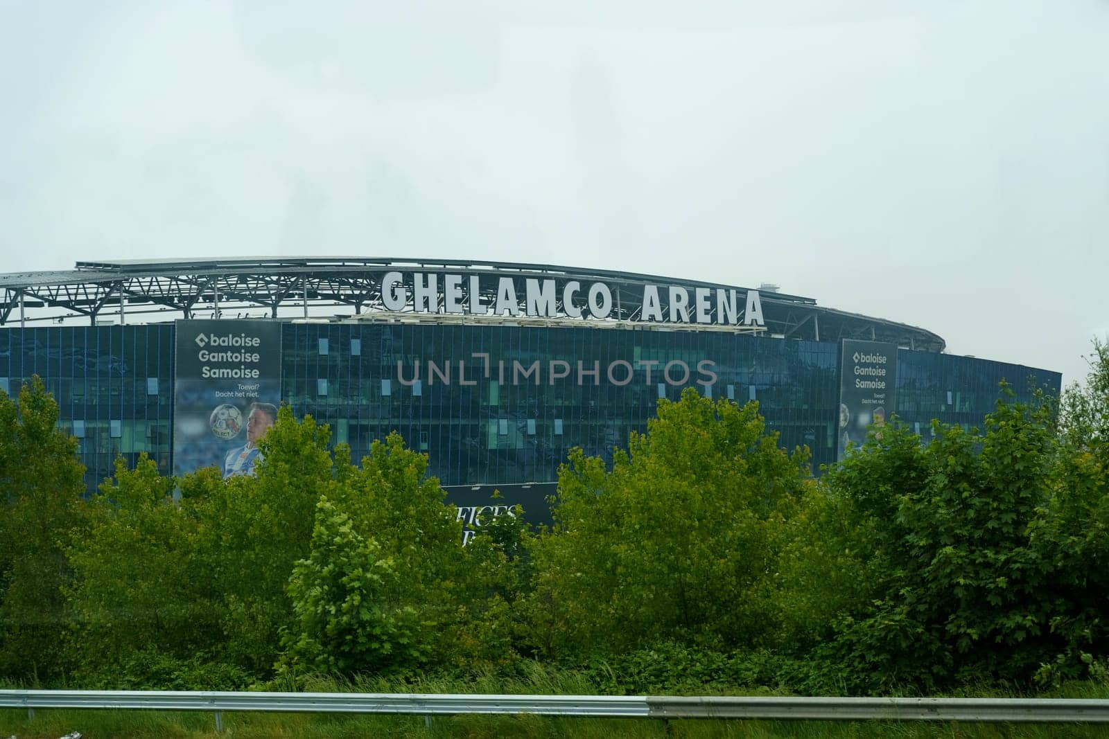 Ghent, Belgium - May 22, 2023: Ghelamco Arena, the home of KAA Gent football club, looms against a backdrop of gray skies, displaying its modern architecture and branding.