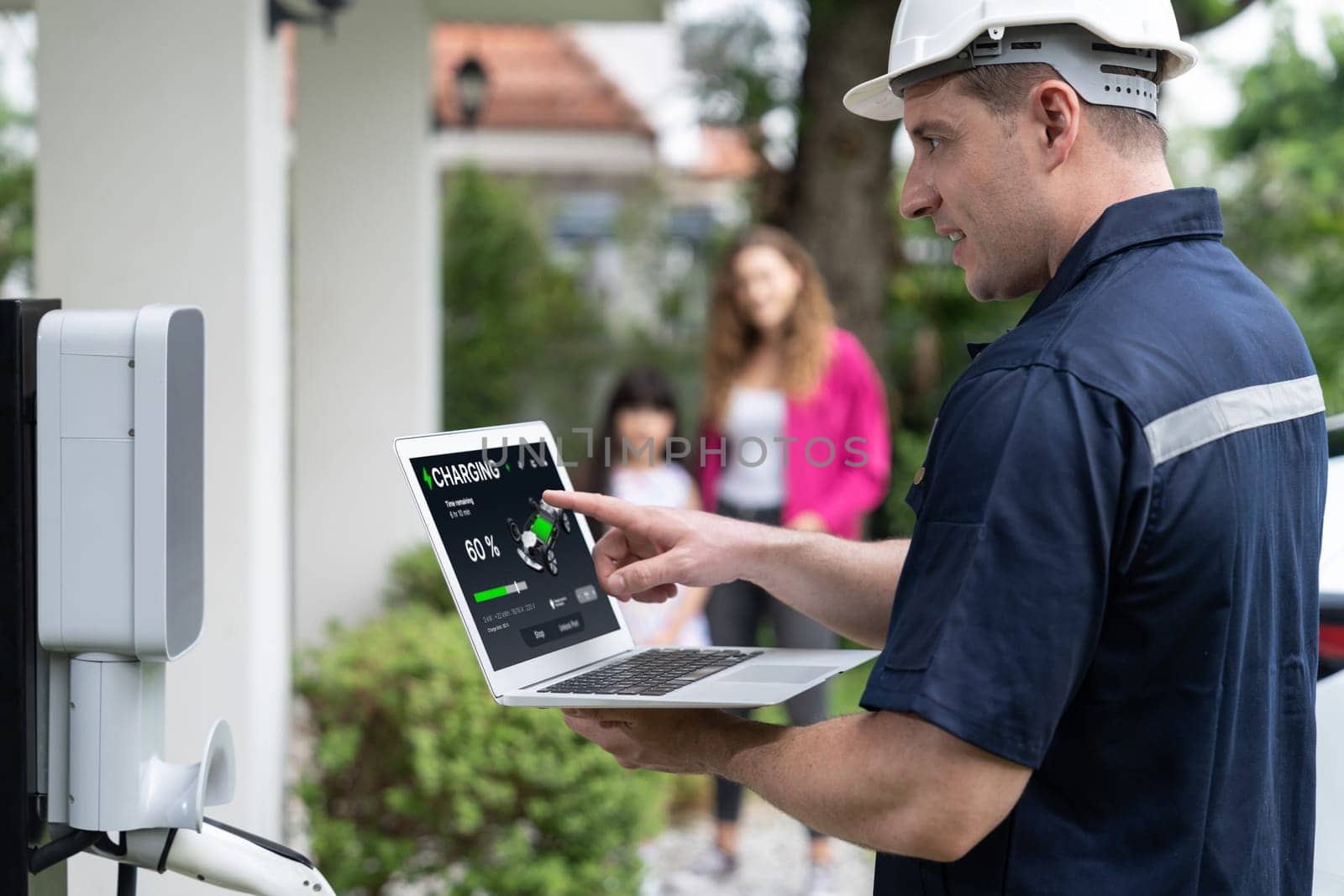 Qualified technician working with laptop for home EV station. Synchronos by biancoblue