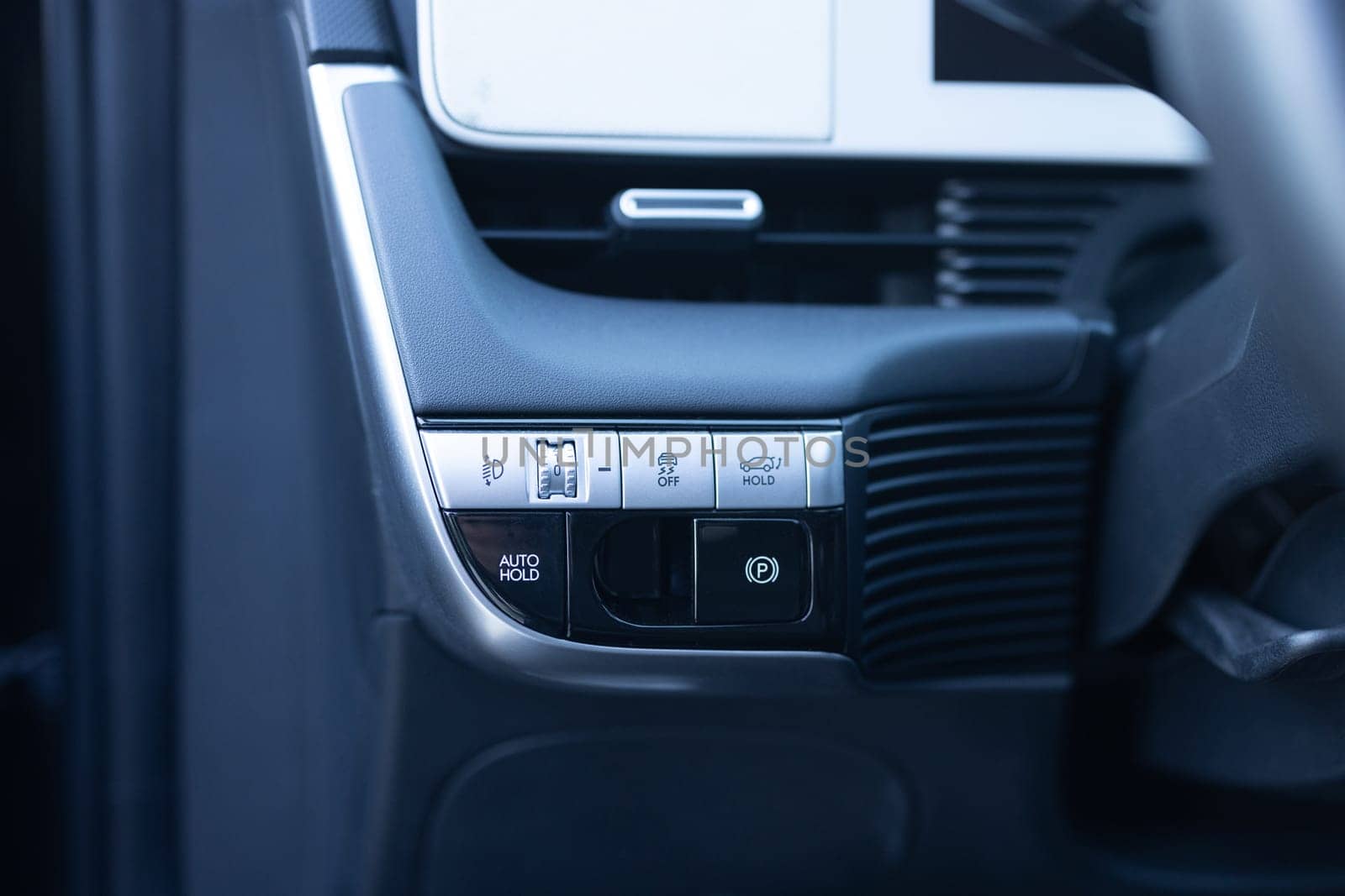 Auto hold button in a modern vehicle. ESP electronic stability program control. Interior detail of a modern electric car. ESP button. Car light switch. Dimming light button by uflypro