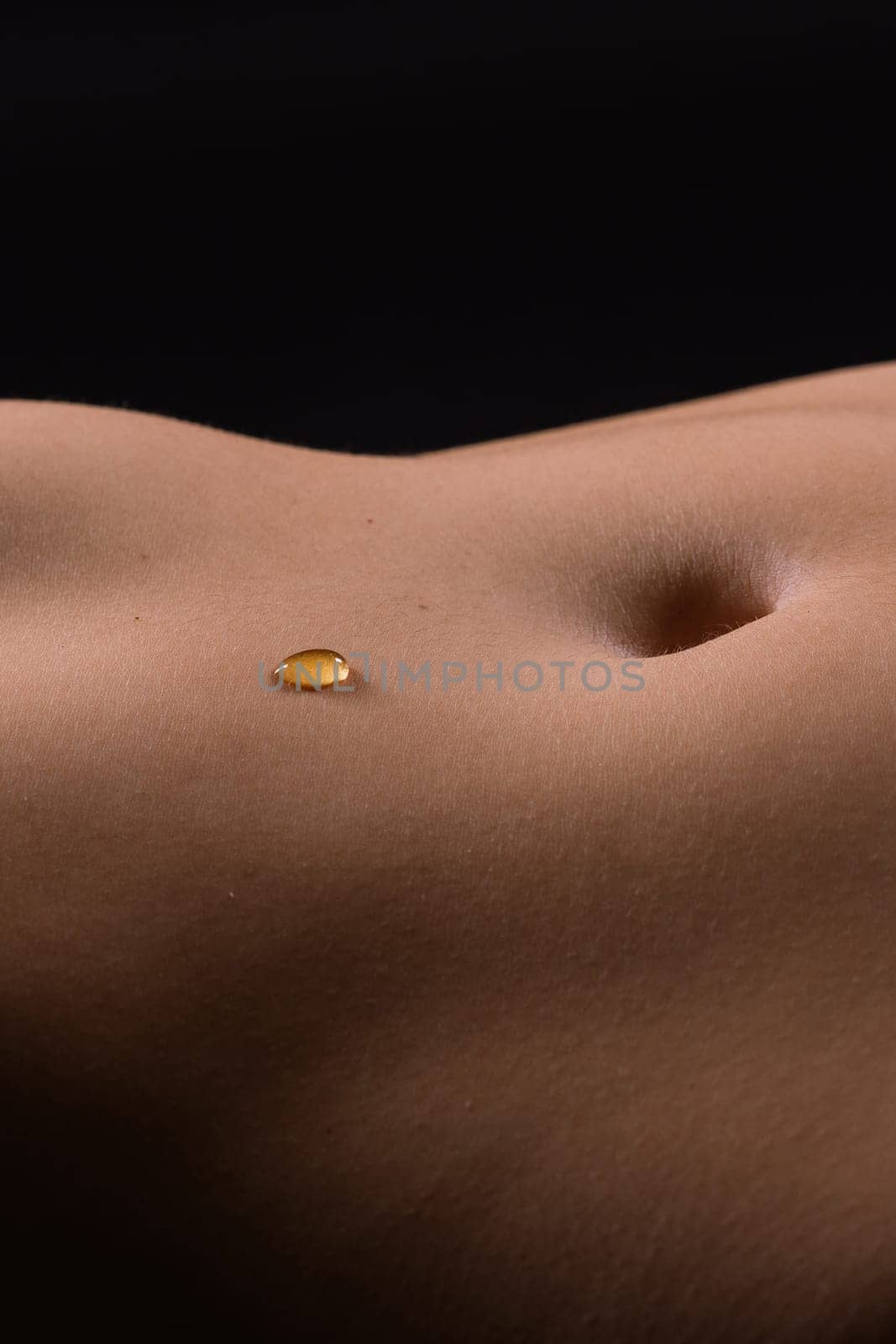 Beautiful female body in honey on dark background, studio by Zelenin