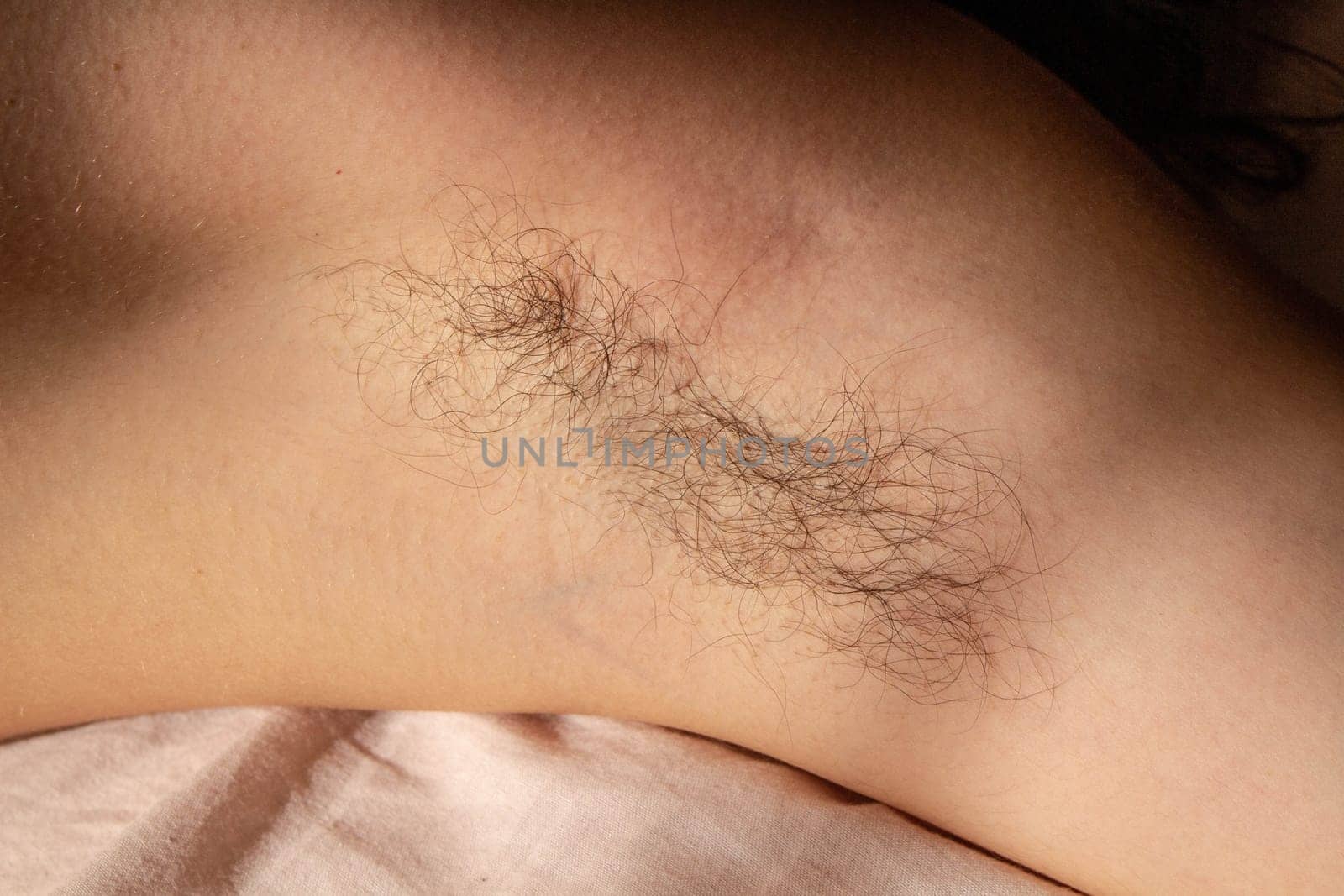 Challenge beauty standards and celebrate natural authenticity with this empowering image of a female armpit adorned with hair