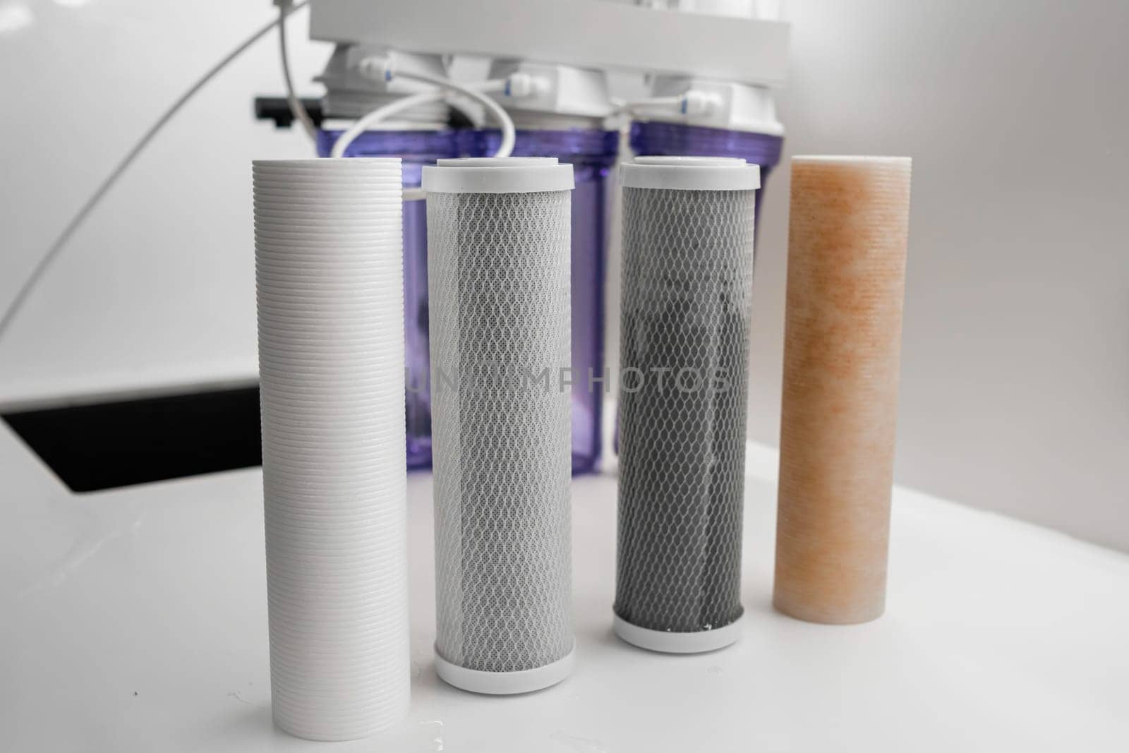 Four filters for the purification system of water on the table in the kitchen