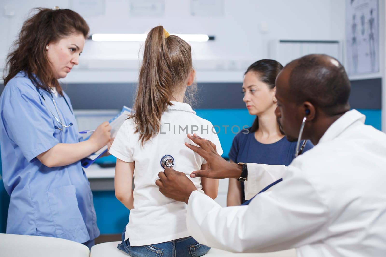 African american doctor using stethoscope for heart checkup of a child. At clinic consultation session, black man physician using a medical instrument to listen to heartbeat of a young girl.