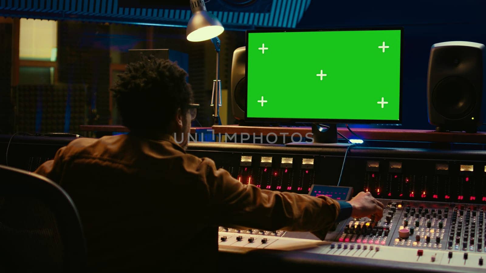 African american audio engineer uses greenscreen on pc by DCStudio