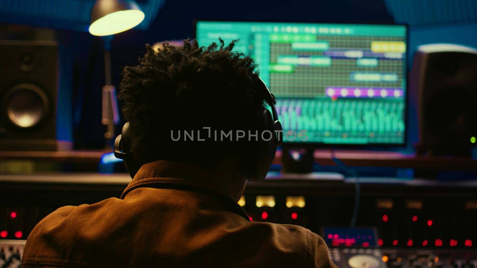 African american tracking engineer processing and mixing sounds in control room by DCStudio