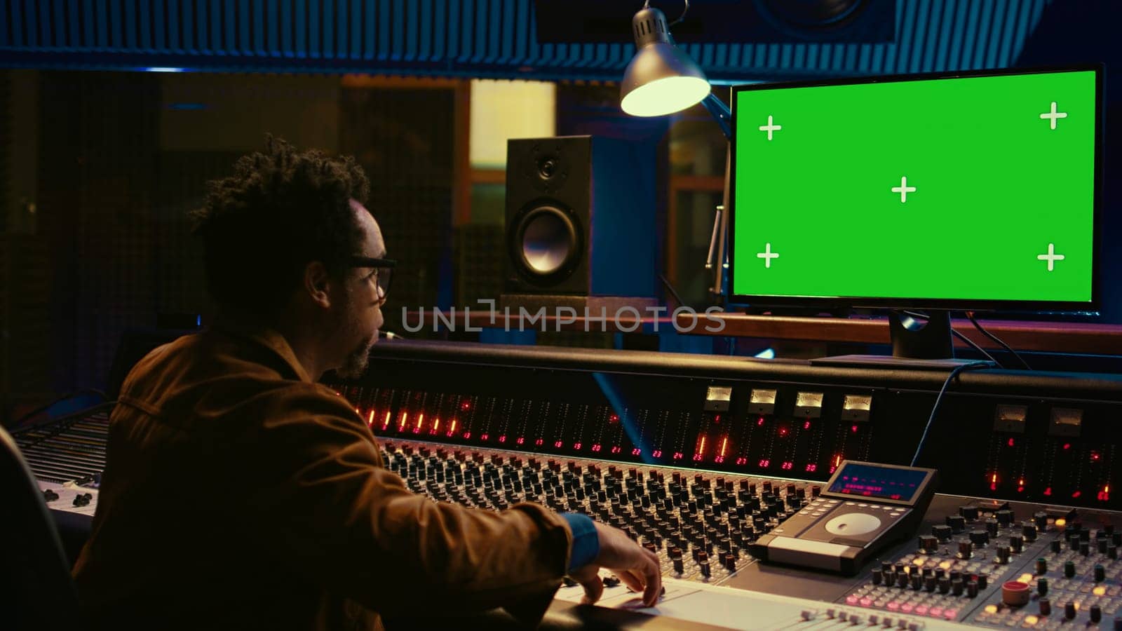 African american sound designer looks at greenscreen to record and edit tunes by DCStudio