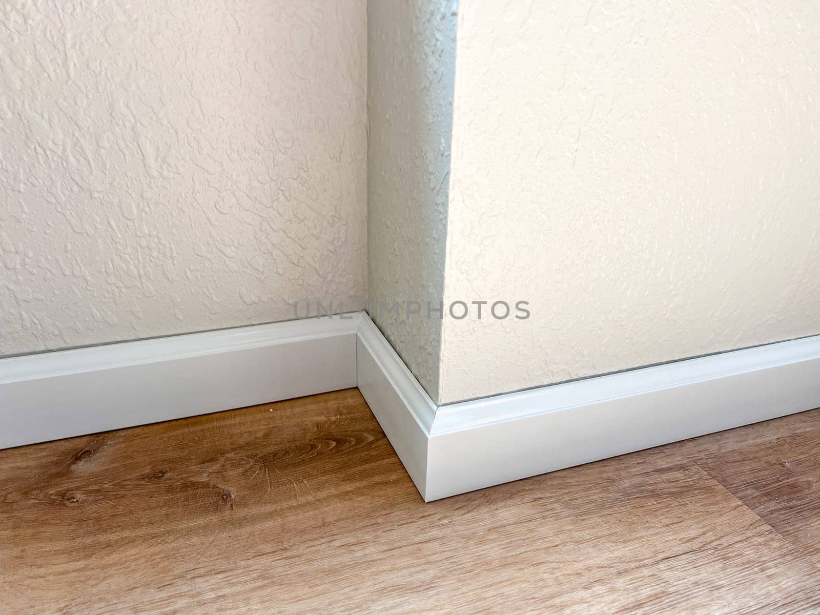 Witness the professional installation of vinyl baseboards in a stylish modern home, adding a sleek finishing touch to the interior design.