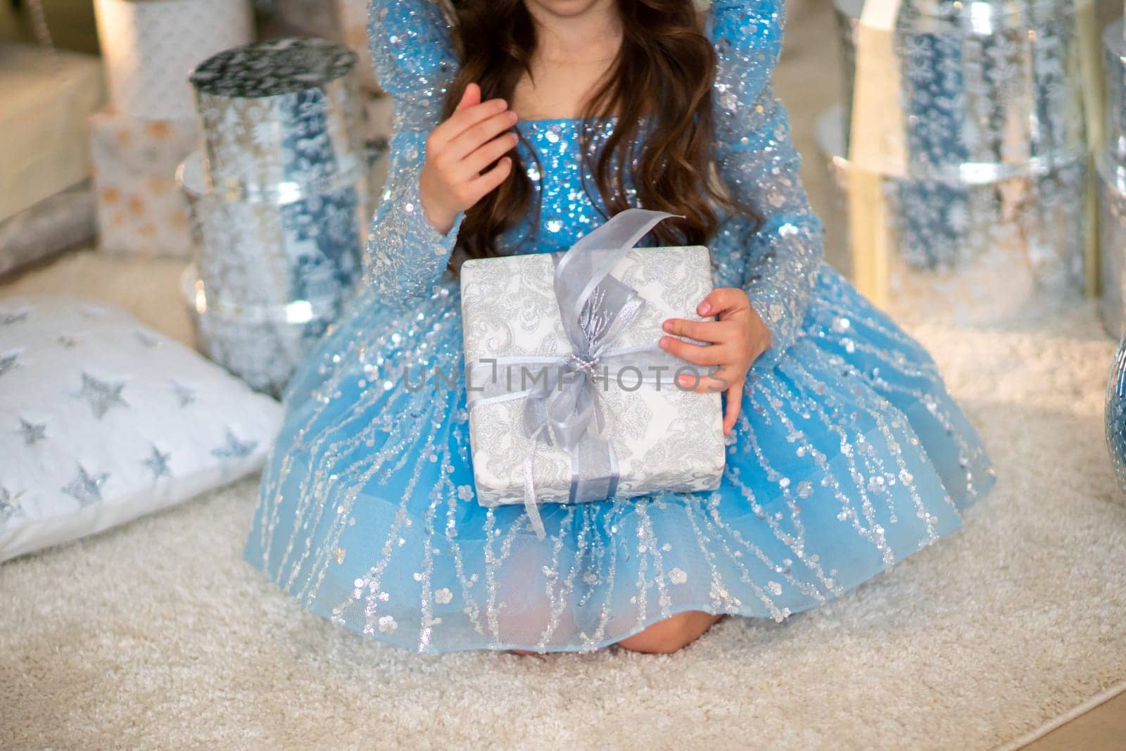 Female hands hold a gift box. Christmas, new year, birthday concept. The girl is dressed in a blue dress and holds out a gift